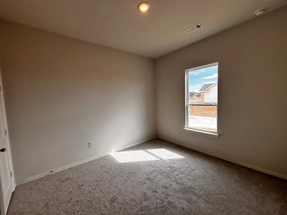 Neutral-toned walls, carpeted flooring, and a single window
