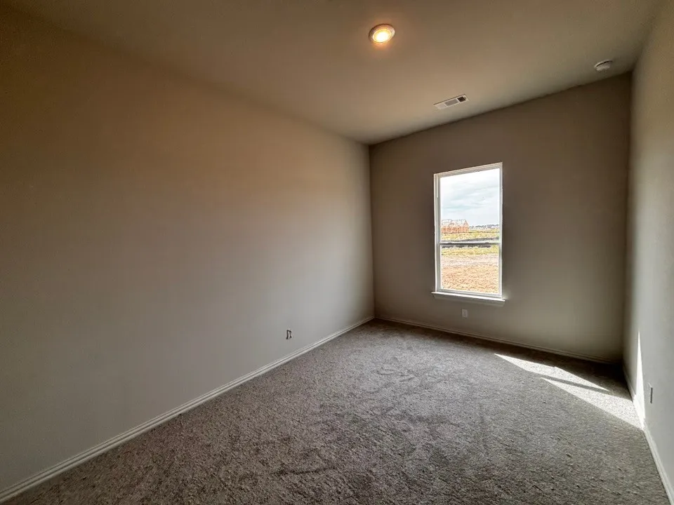 Neutral-toned walls, recessed lighting, and a single-pane window