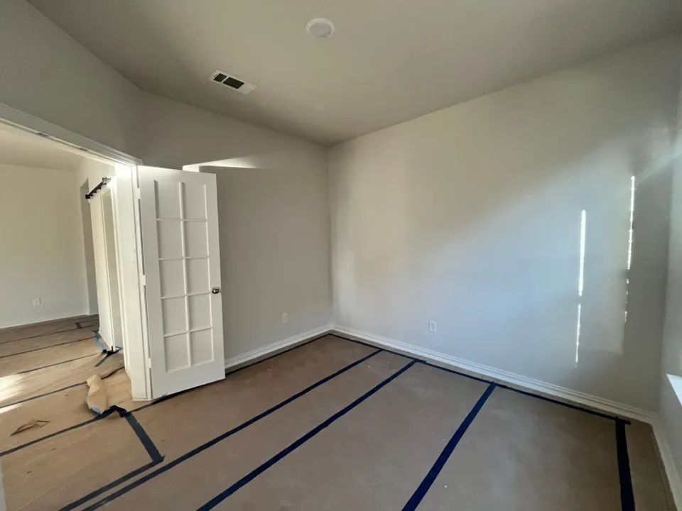 White interior walls, recessed ceiling lighting, window with trim, white trim molding, and a white paneled door