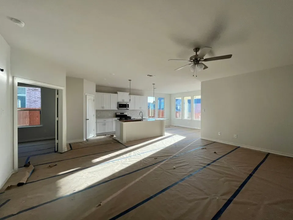 Open-concept living area with a kitchen island, recessed lighting, and a ceiling fan