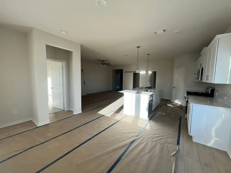 Open-concept living area with integrated kitchen, recessed lighting, and wood-finish flooring