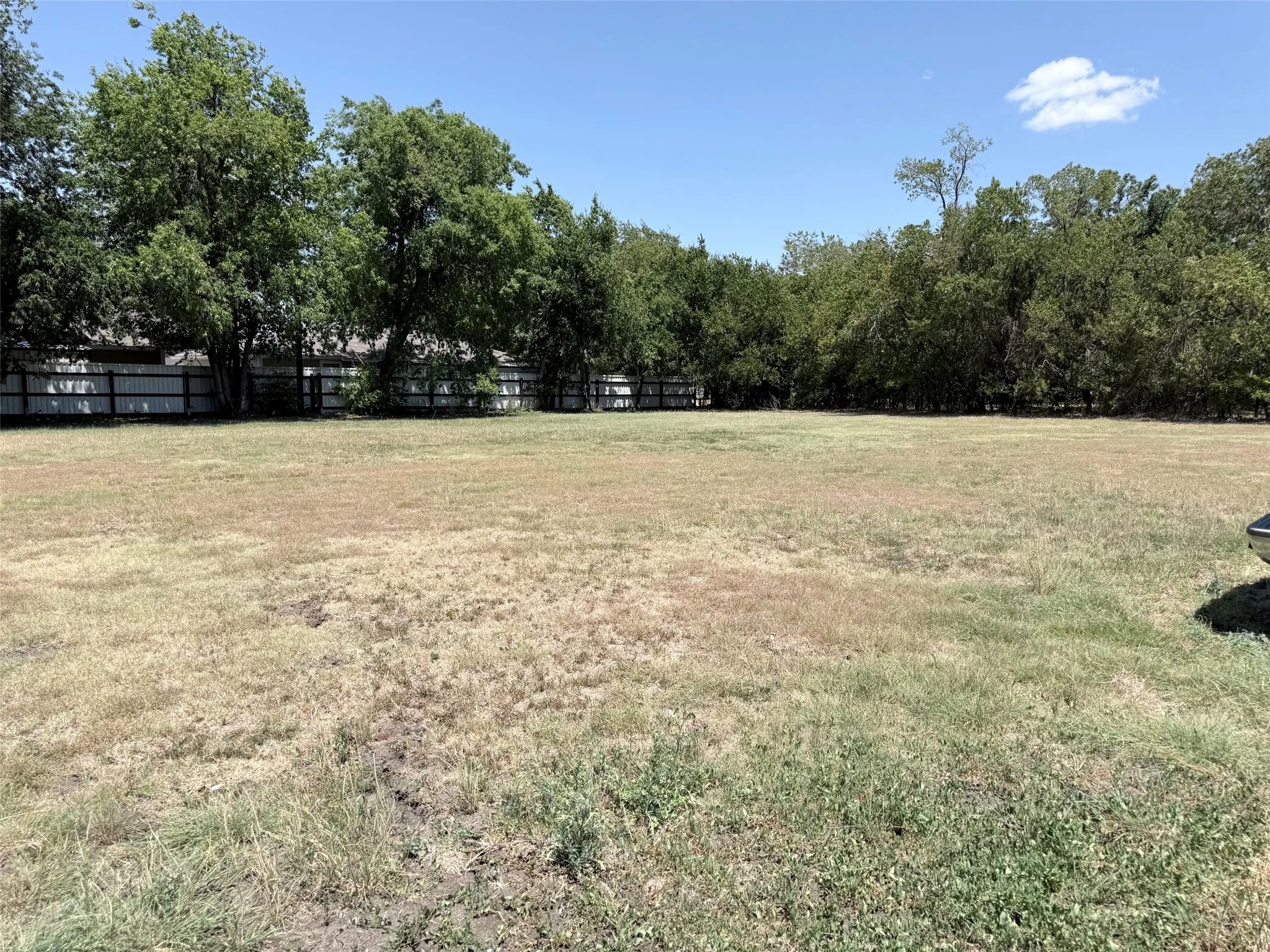 Expansive lot featuring a perimeter fence and mature trees