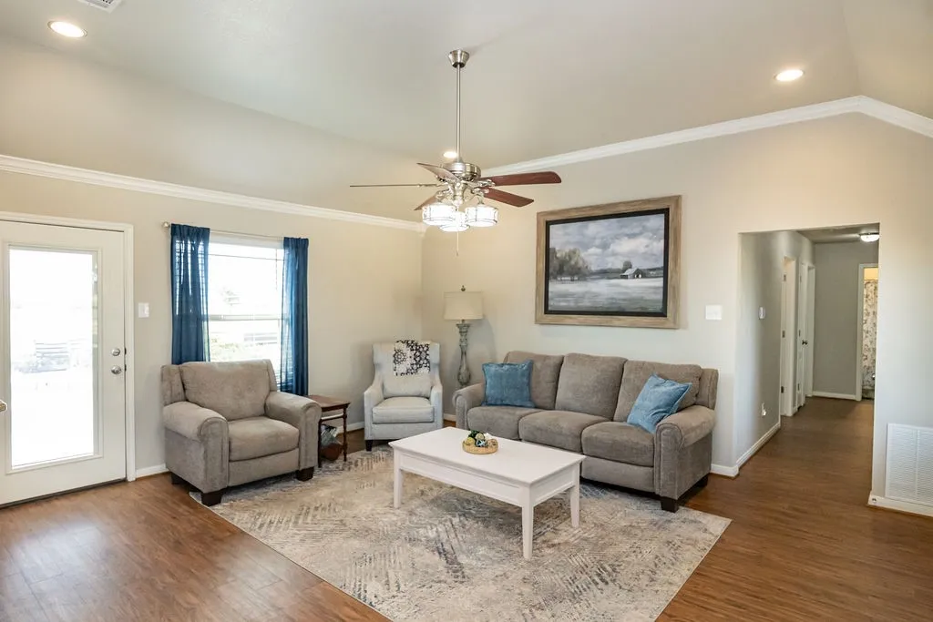 Vaulted ceiling with recessed lighting, wood-finish flooring, ceiling fan, and crown molding