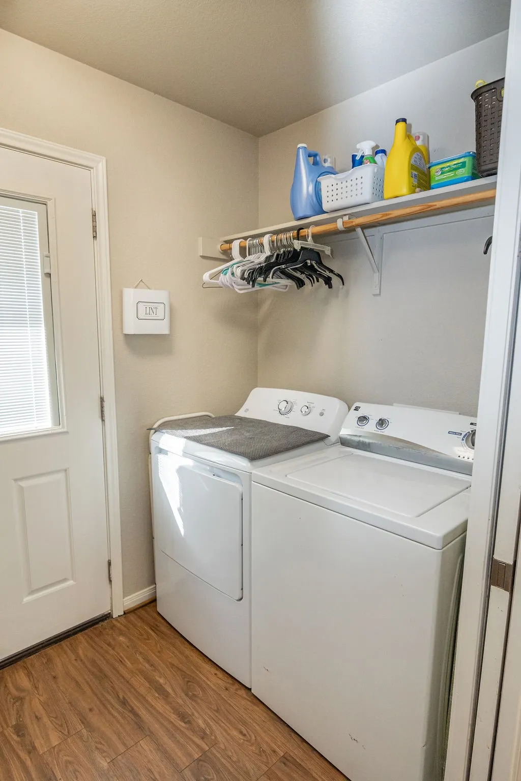Wood-finish flooring, overhead shelving, and a full-light exterior door