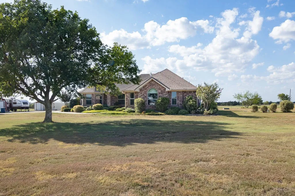 Brick residence situated on expansive acreage with mature shade trees and open grounds