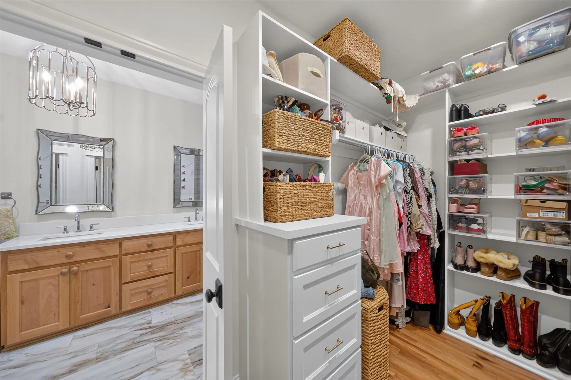 Custom closet system with white shelving, integrated drawers, and hardwood flooring