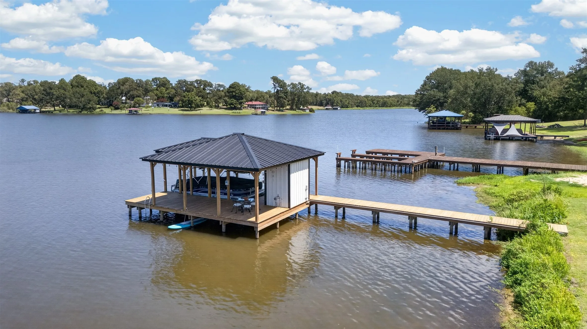 Private boat dock featuring a covered boat slip, extended deck, and private walkway