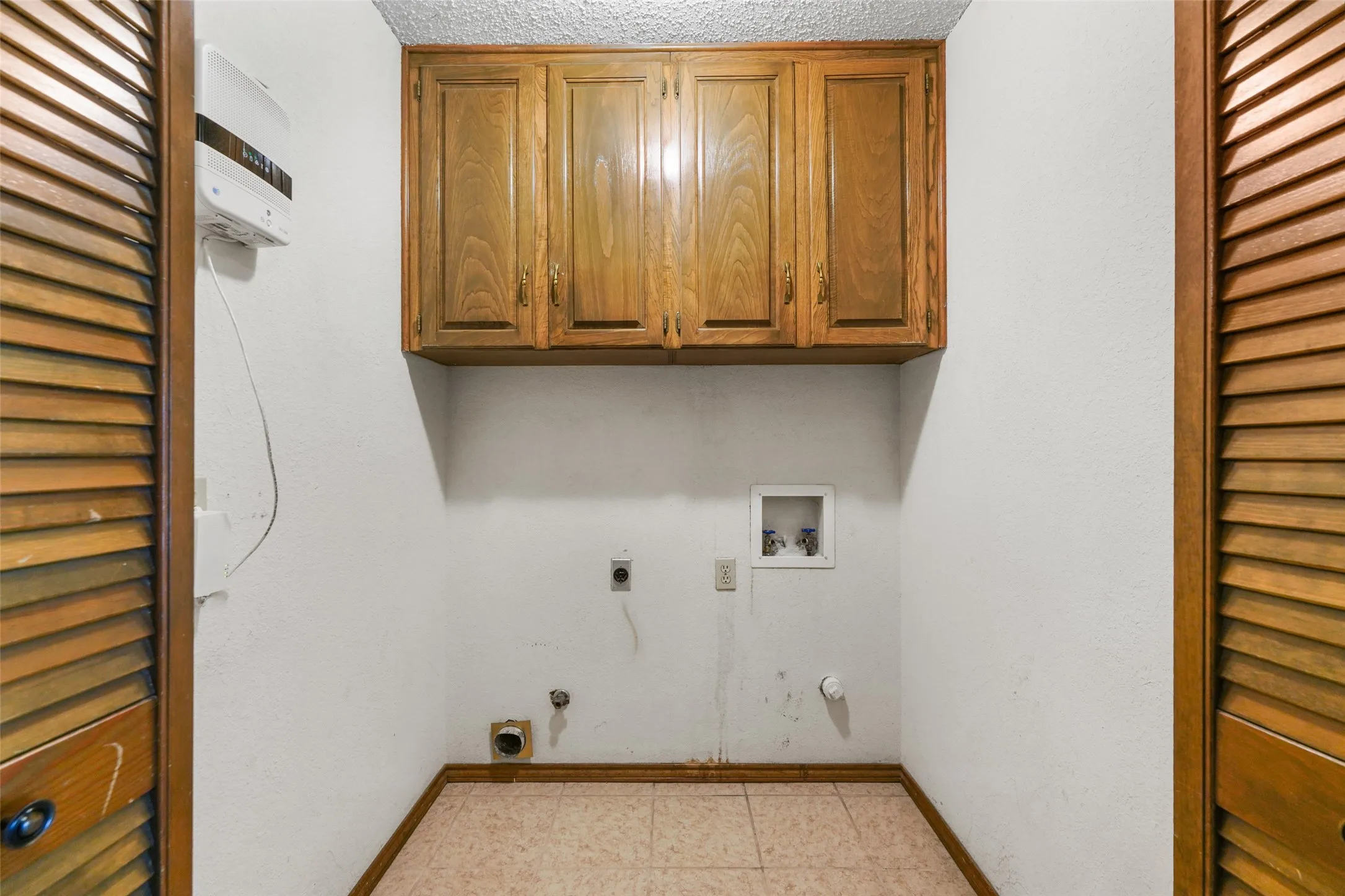 Built-in wood cabinetry with visible grain, louvered wood doors, and tiled flooring