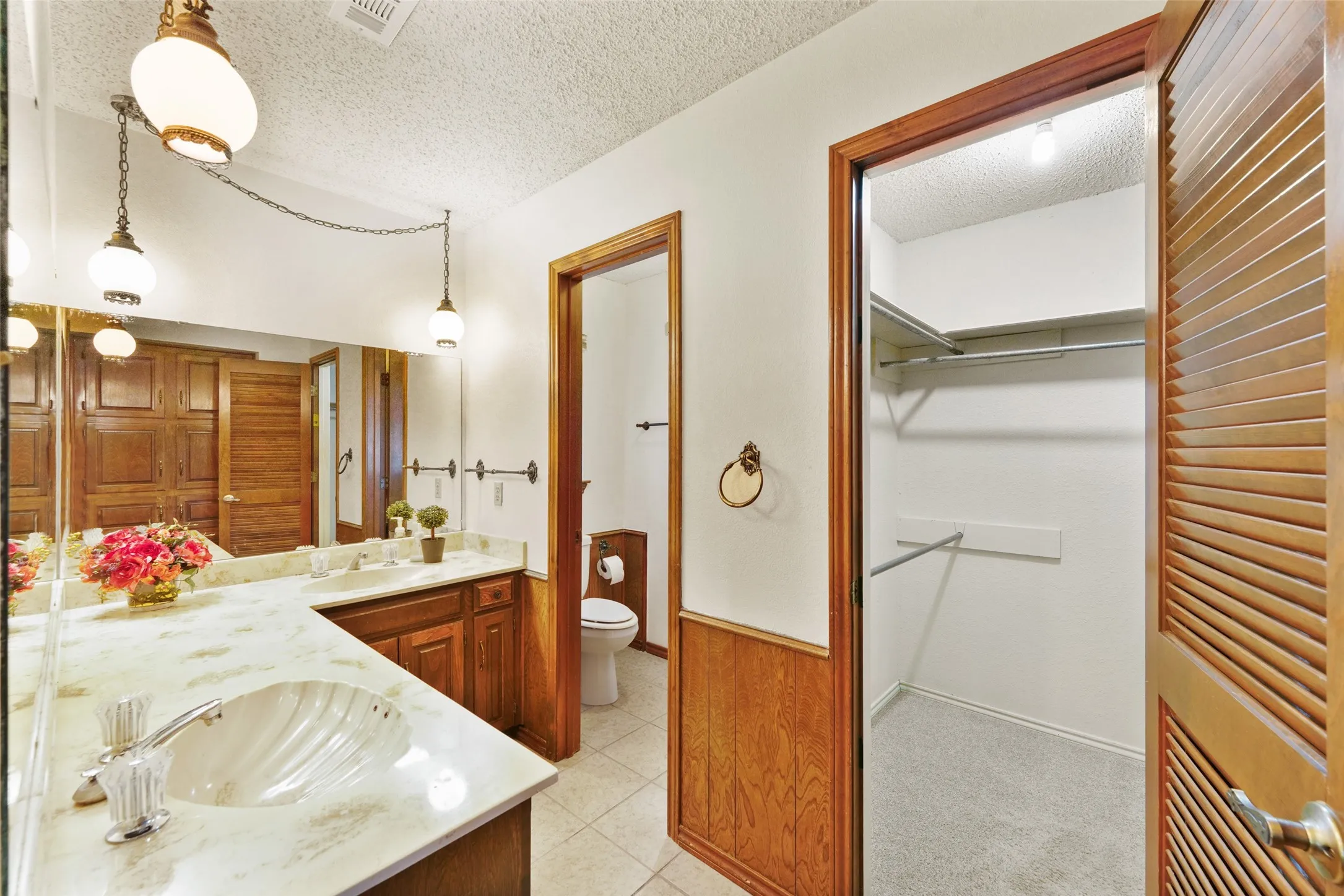 Double vanity with shell-shaped sinks and stone-finish countertop
