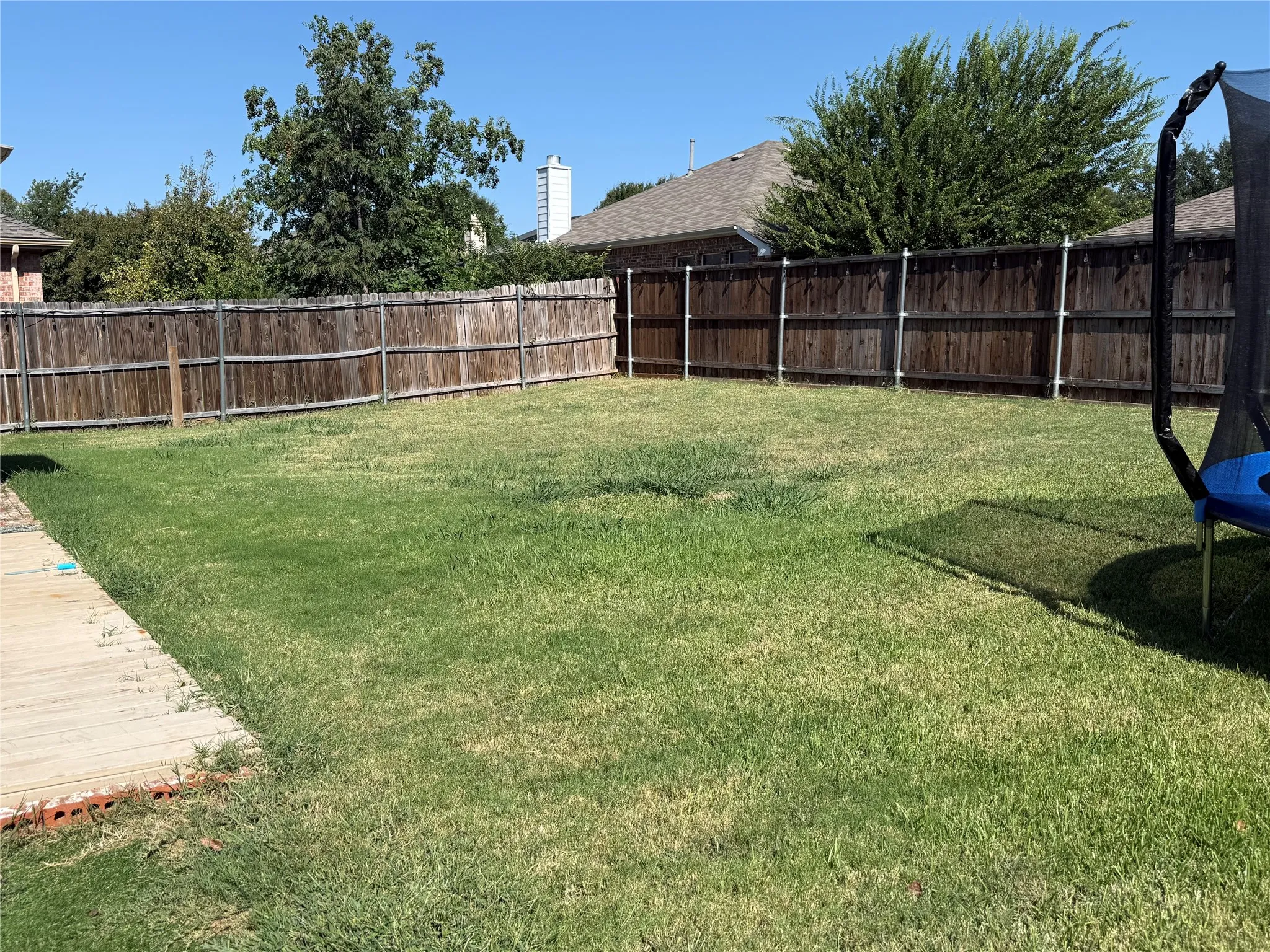 Expansive backyard with a wood privacy fence and a manicured lawn