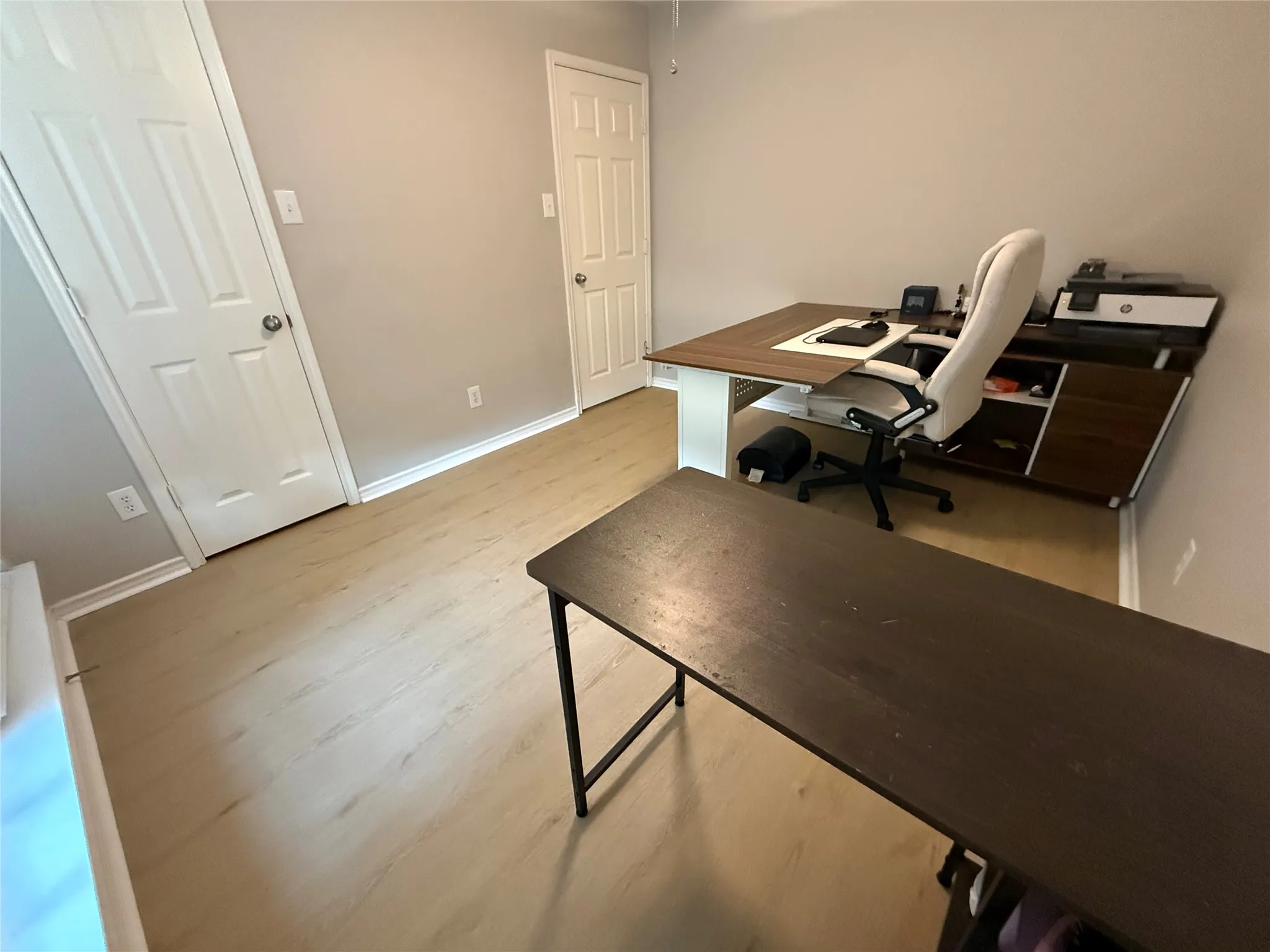 Wood-finish flooring with light wall tones and white trim