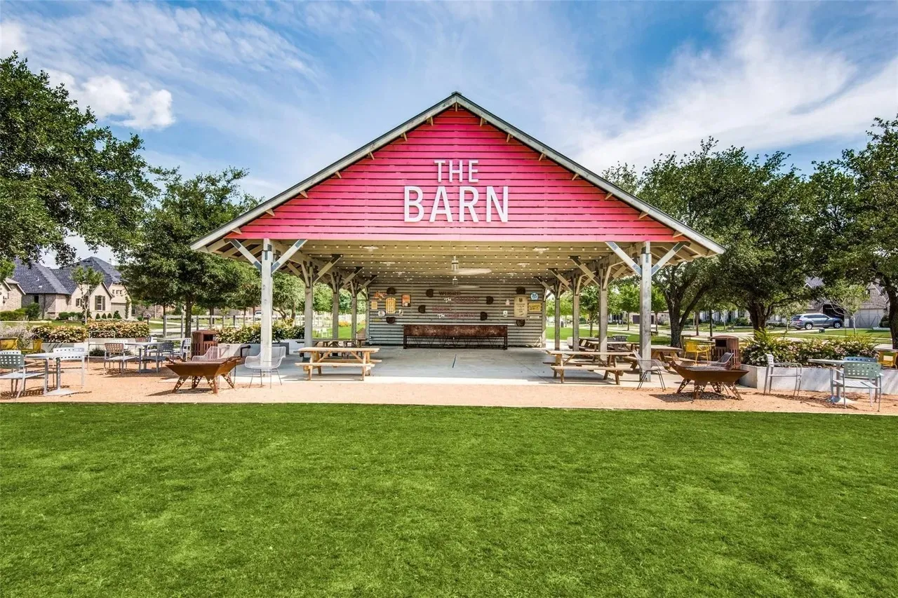 The Barn features a distinctive red gabled roof with white trim and signage, sheltering an open-air pavilion structure