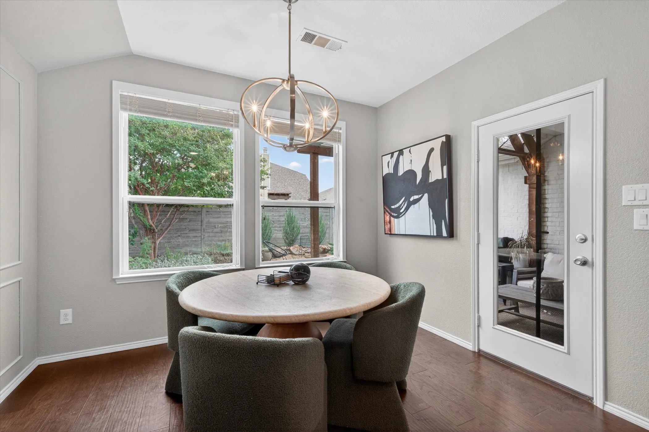 Dining area featuring wood-finish flooring and a contemporary chandelier