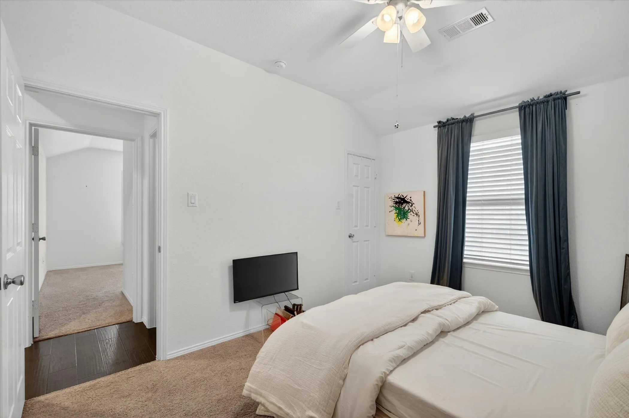 Carpeted room featuring a ceiling fan, window with blinds, and white paneled doors