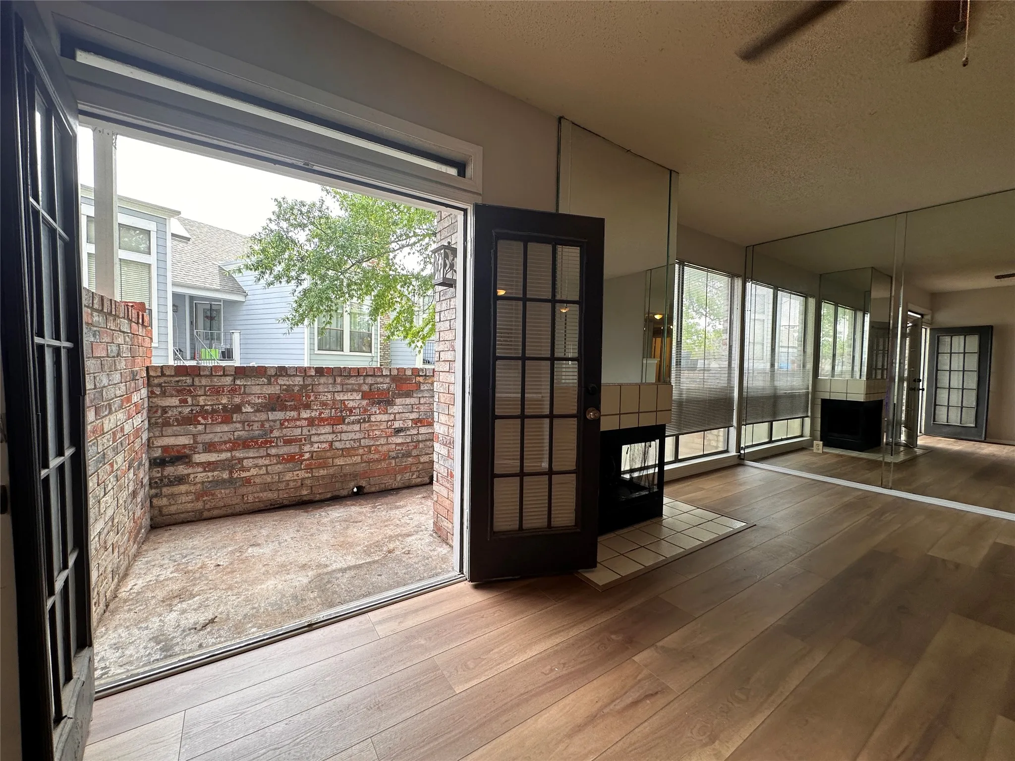 Entryway with hardwood / wood-style flooring, brick wall, and ceiling fan