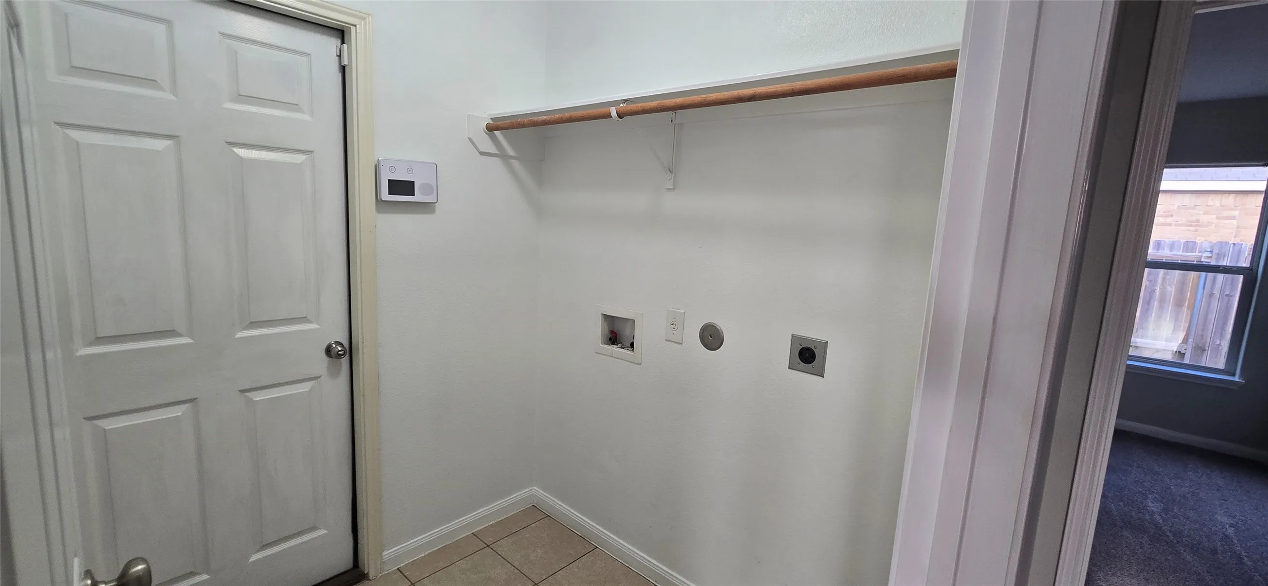 Laundry area with hookup for a washing machine, baseboards, laundry area, electric dryer hookup, and light tile patterned floors