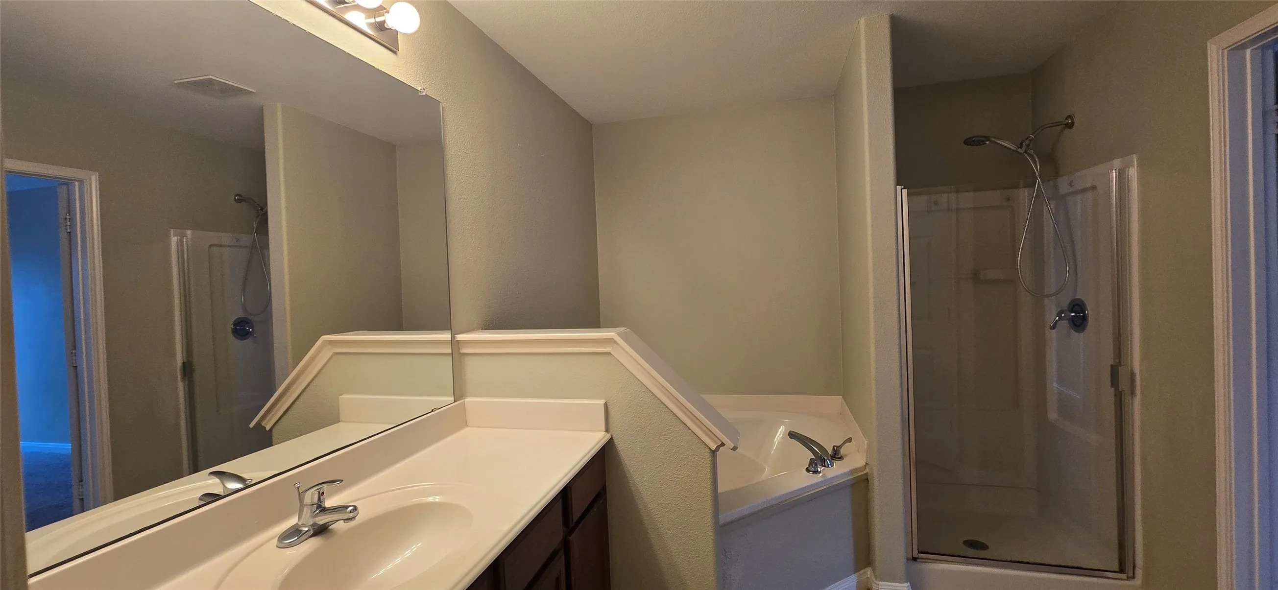 Full bathroom featuring vanity, visible vents, and a shower stall