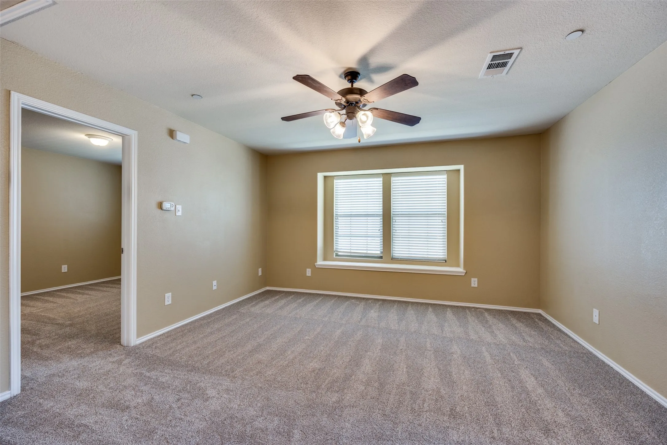 Room featuring textured carpeting, a ceiling fan with integrated lighting, window blinds, and recessed lighting