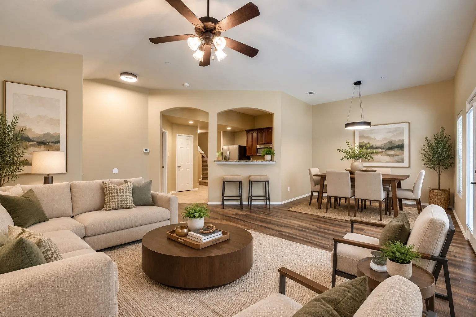 Open-concept living space featuring wood-finish flooring, recessed lighting, and archway entries