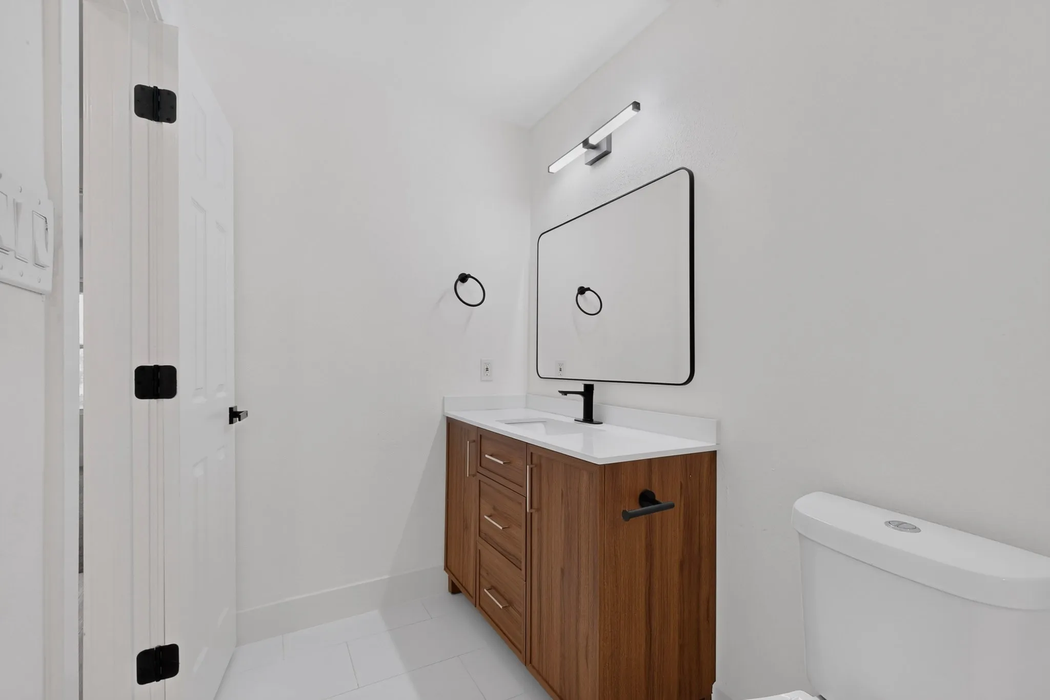 Wood-finish vanity with a white countertop and rectangular sink