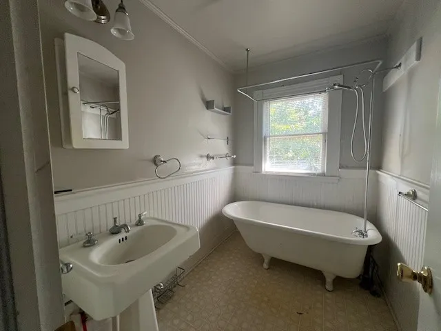Bathroom featuring ornamental molding and sink