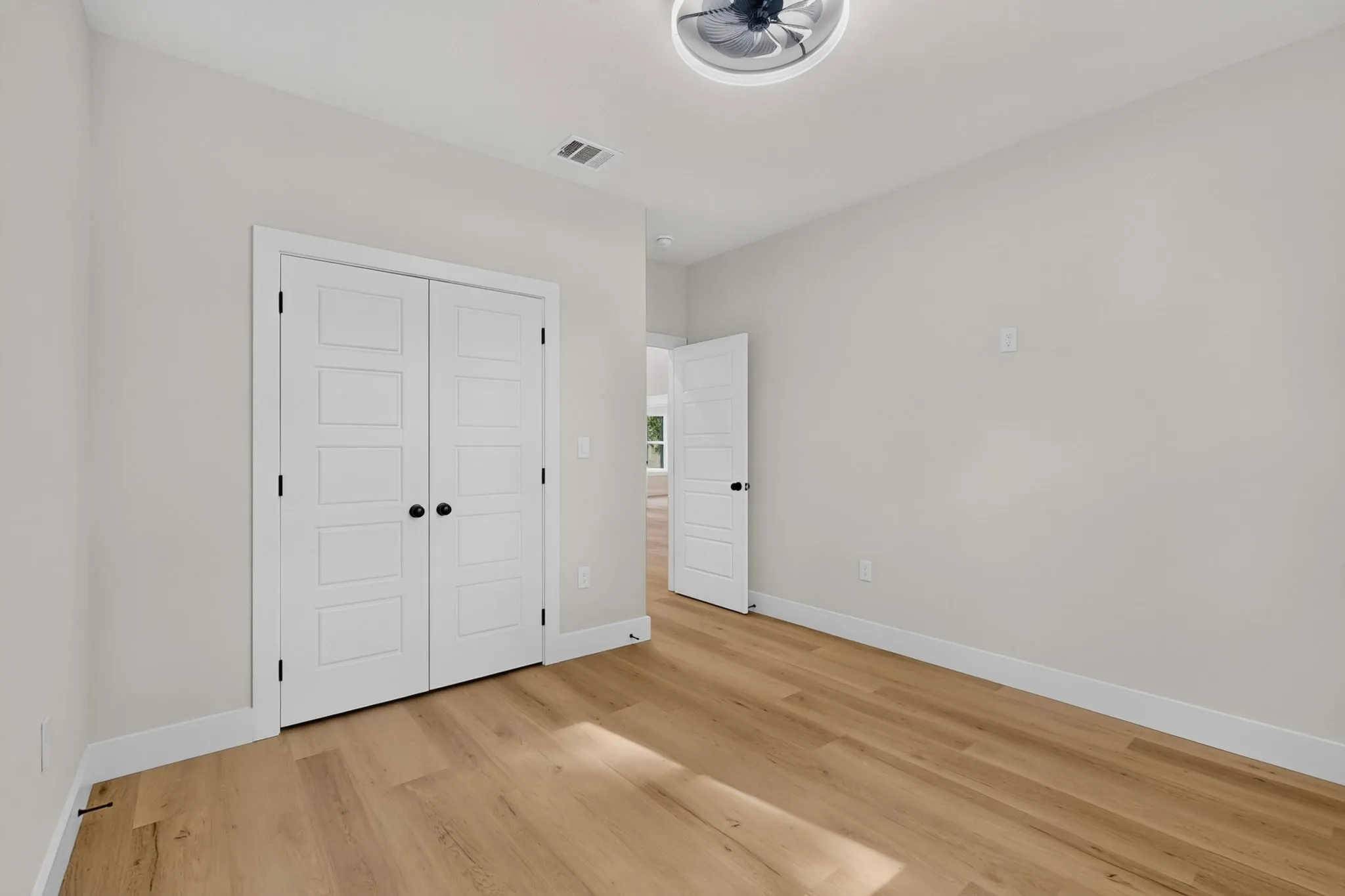 Light wood-finish flooring with white trim