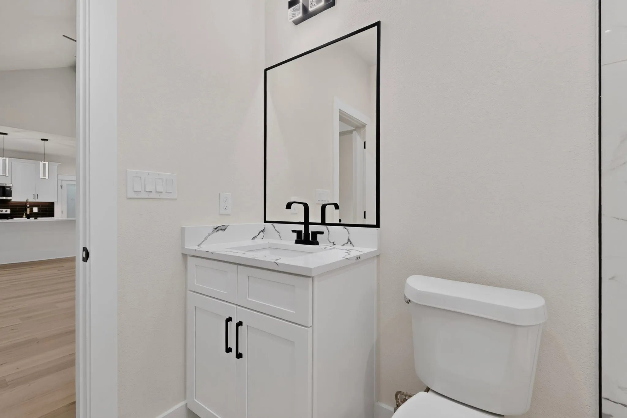 White vanity with matte black hardware, integrated sink, and white countertop