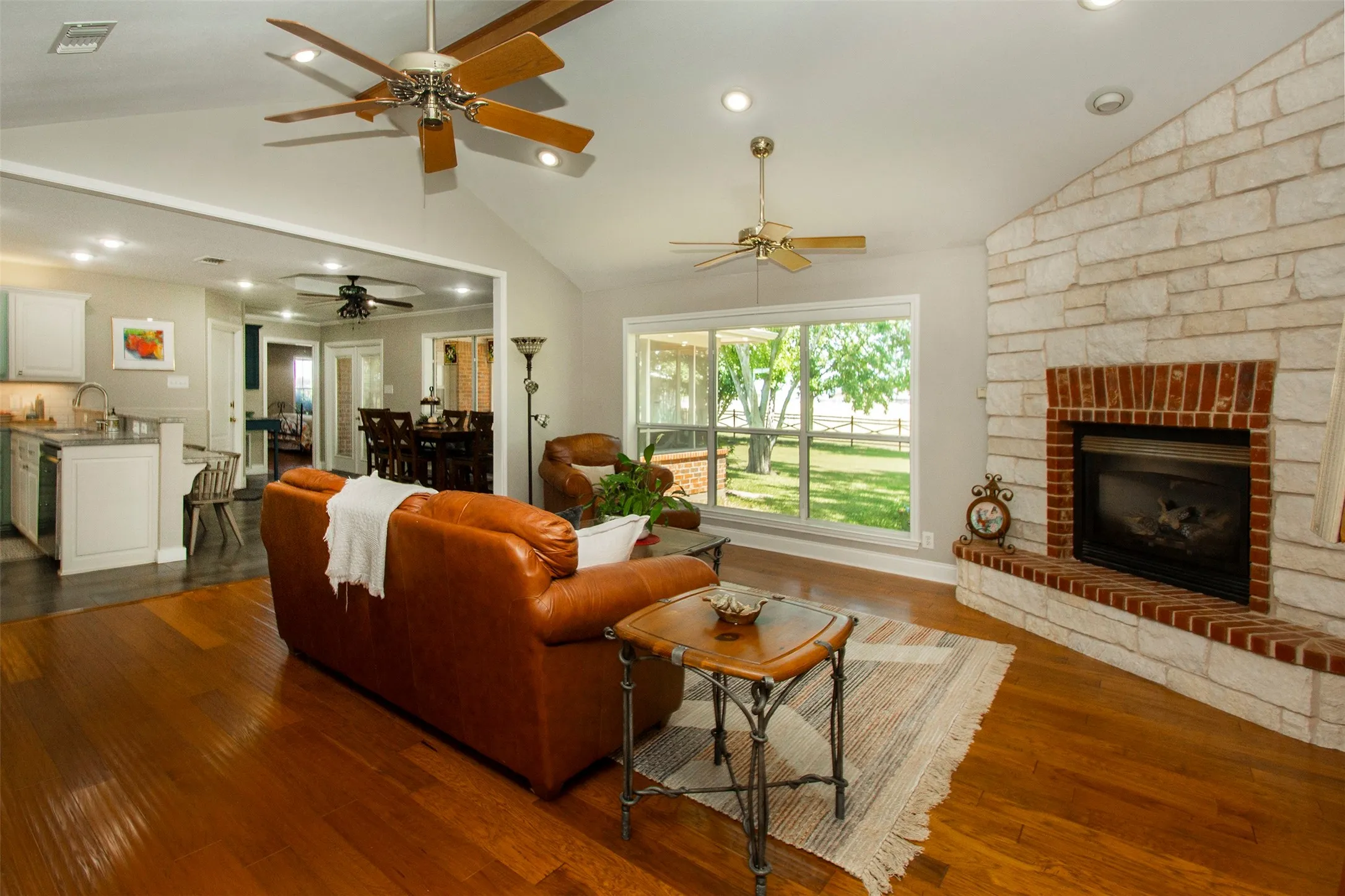 Spacious living room with expansive views of the treed backyard and acreage