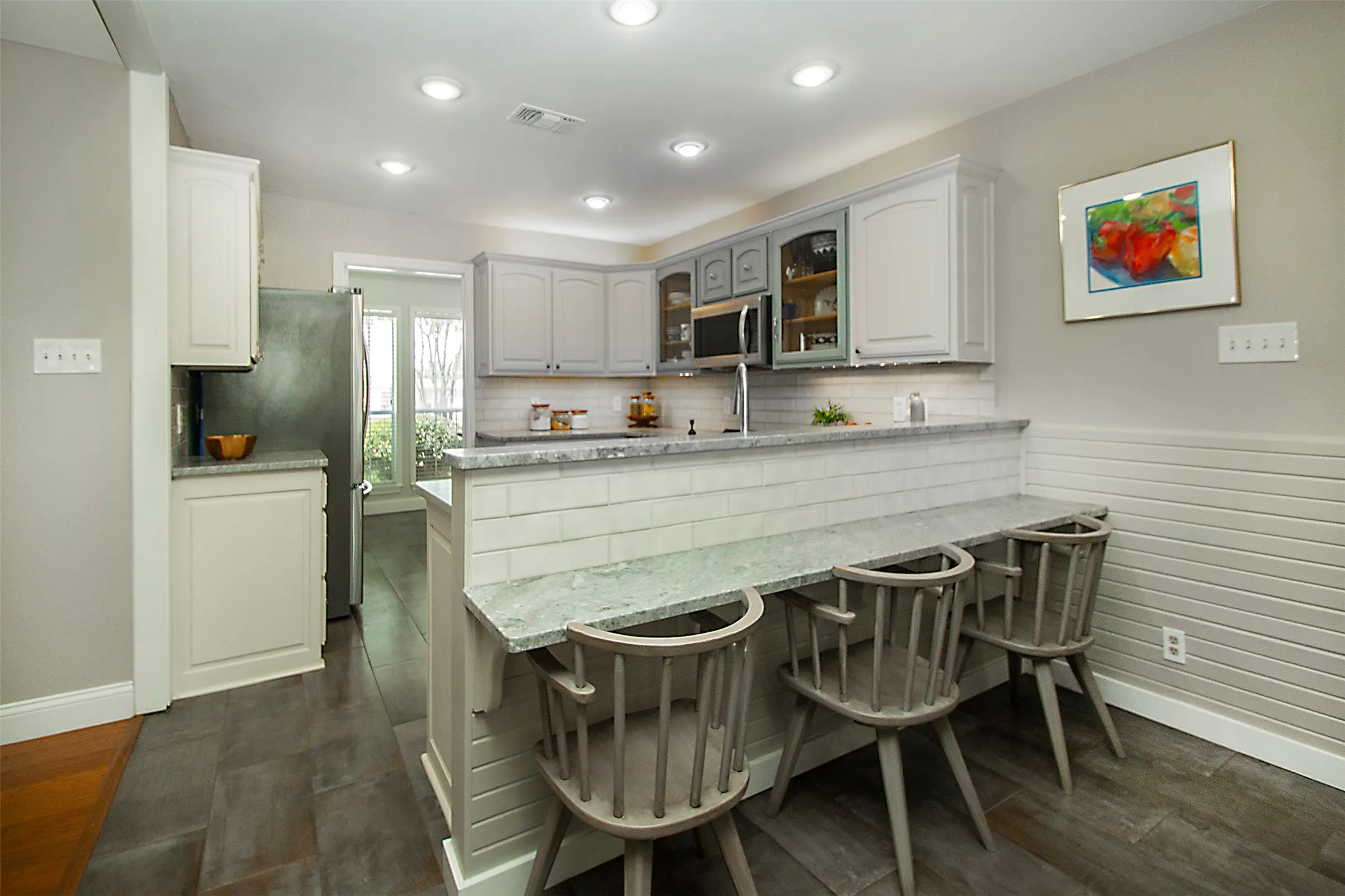 Open concept kitchen with updated honed marble countertops