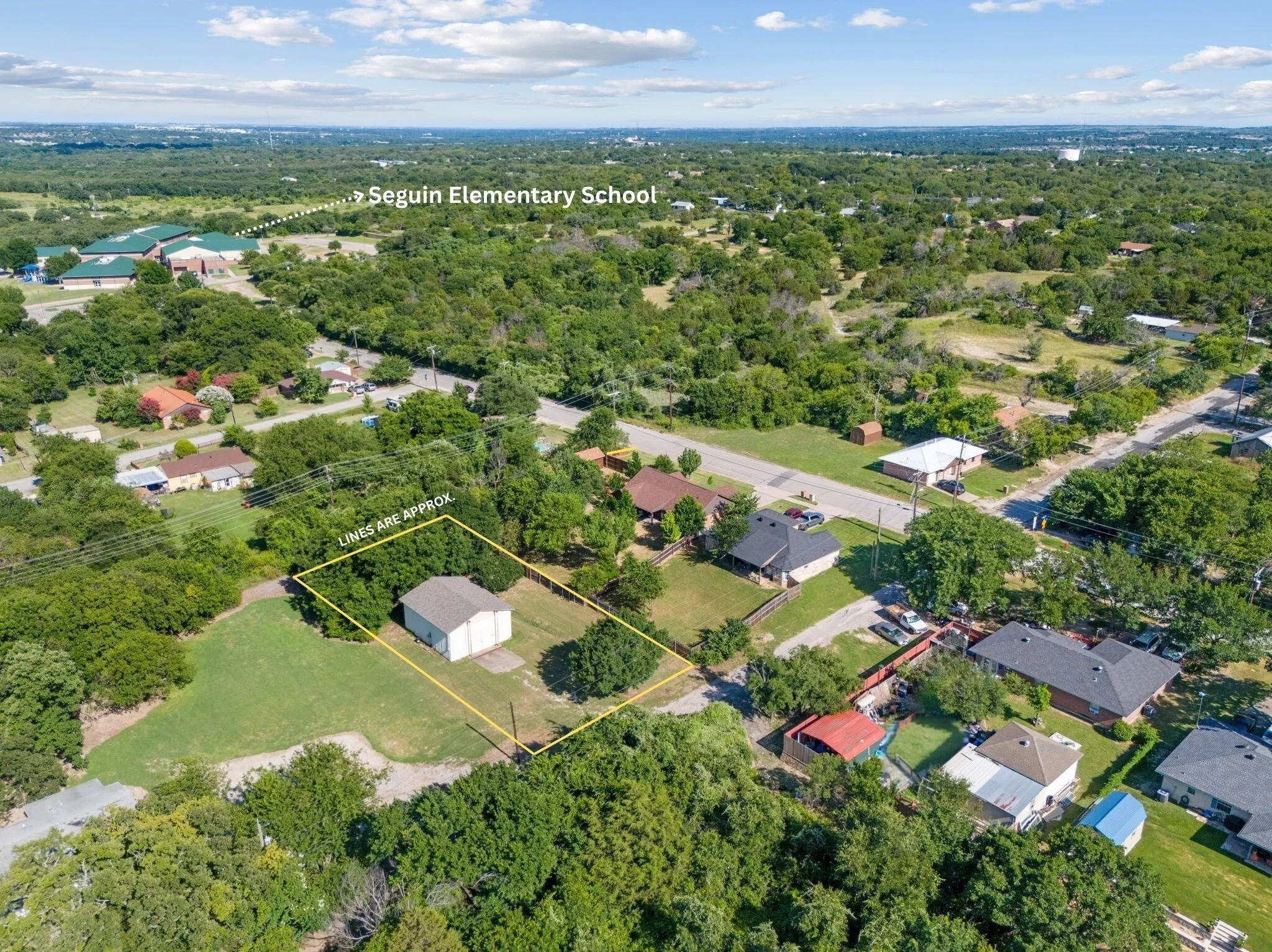 Aerial view of property and surrounding area with property boundaries highlighted and a heavily wooded area