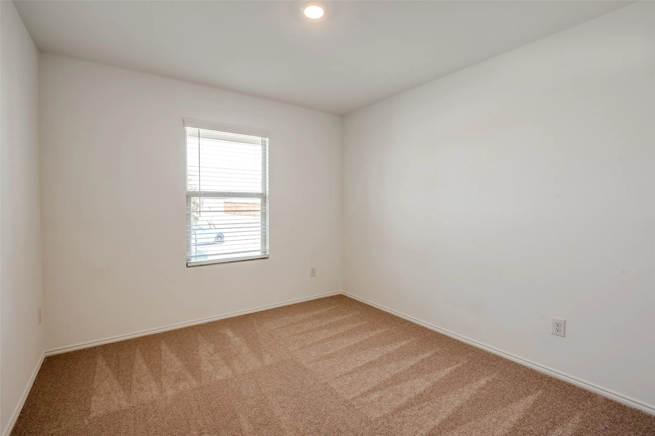 Recessed ceiling lighting, window with blinds, and neutral tone carpeting