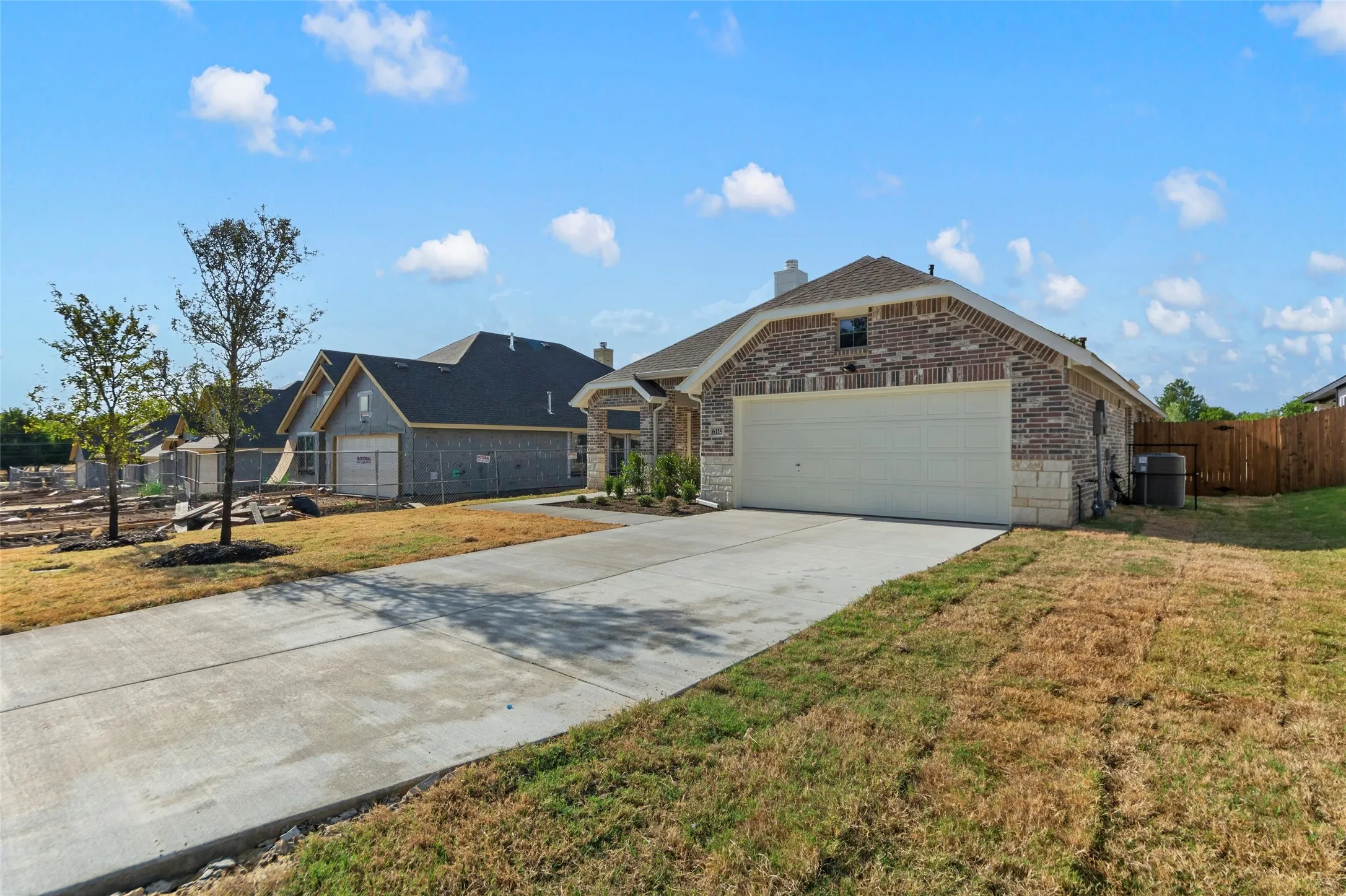 Brick and stone exterior with a concrete driveway and an attached garage