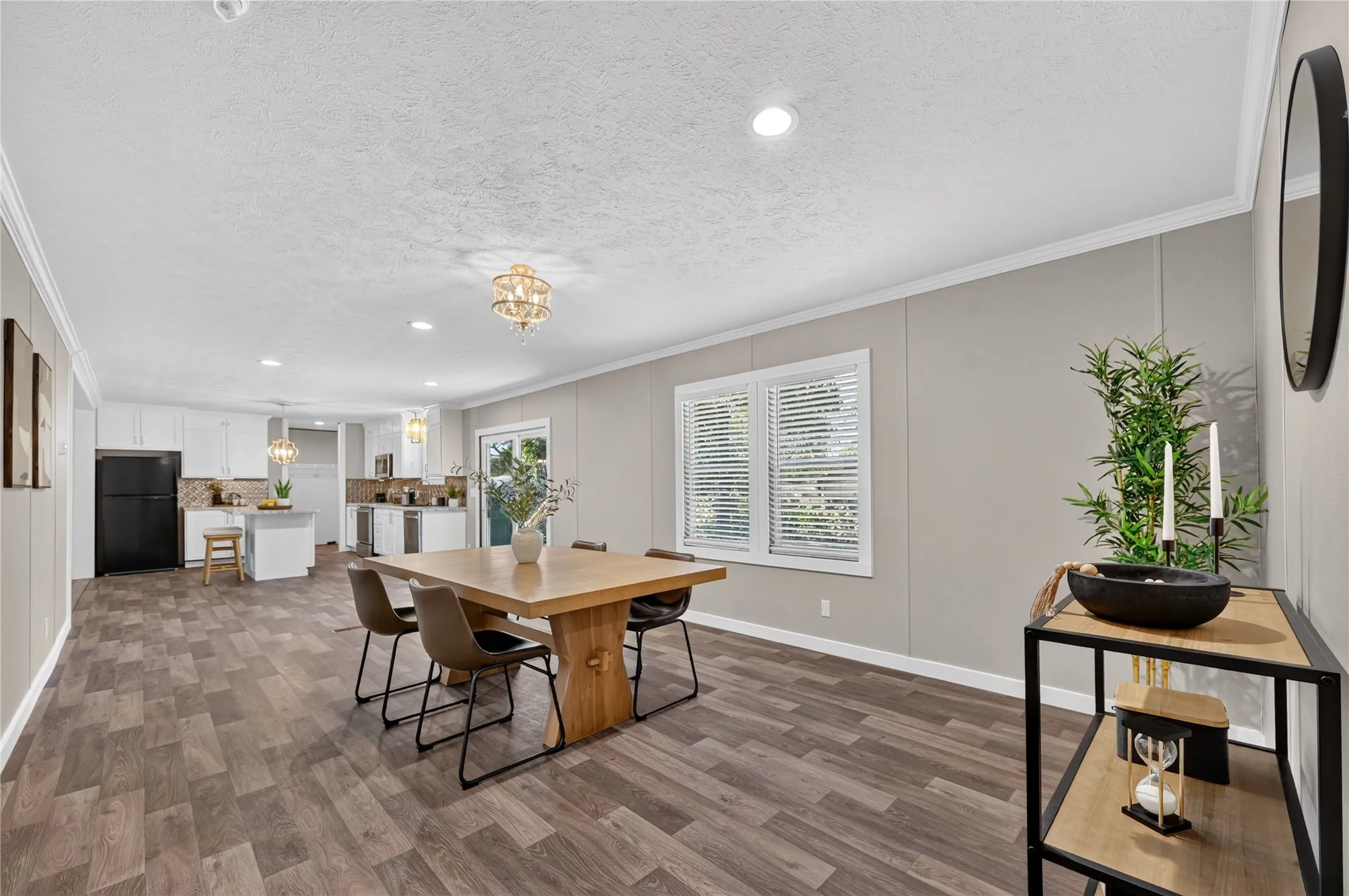 Open-concept living space featuring wood-finish flooring, recessed lighting, and a kitchen with white cabinetry
