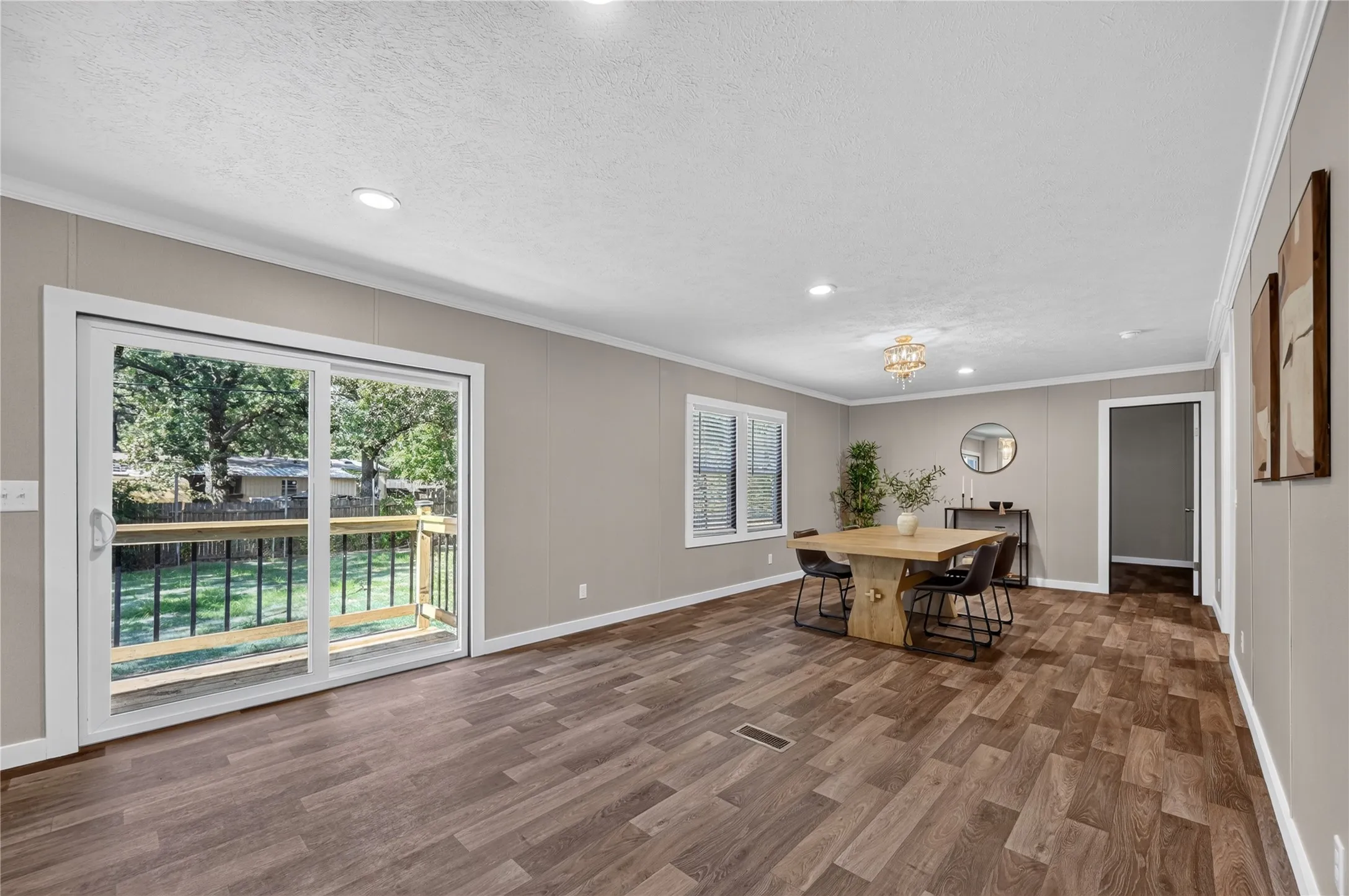 Sliding glass patio door, wood-finish flooring, recessed lighting, white window trim, and a built-in ceiling light fixture