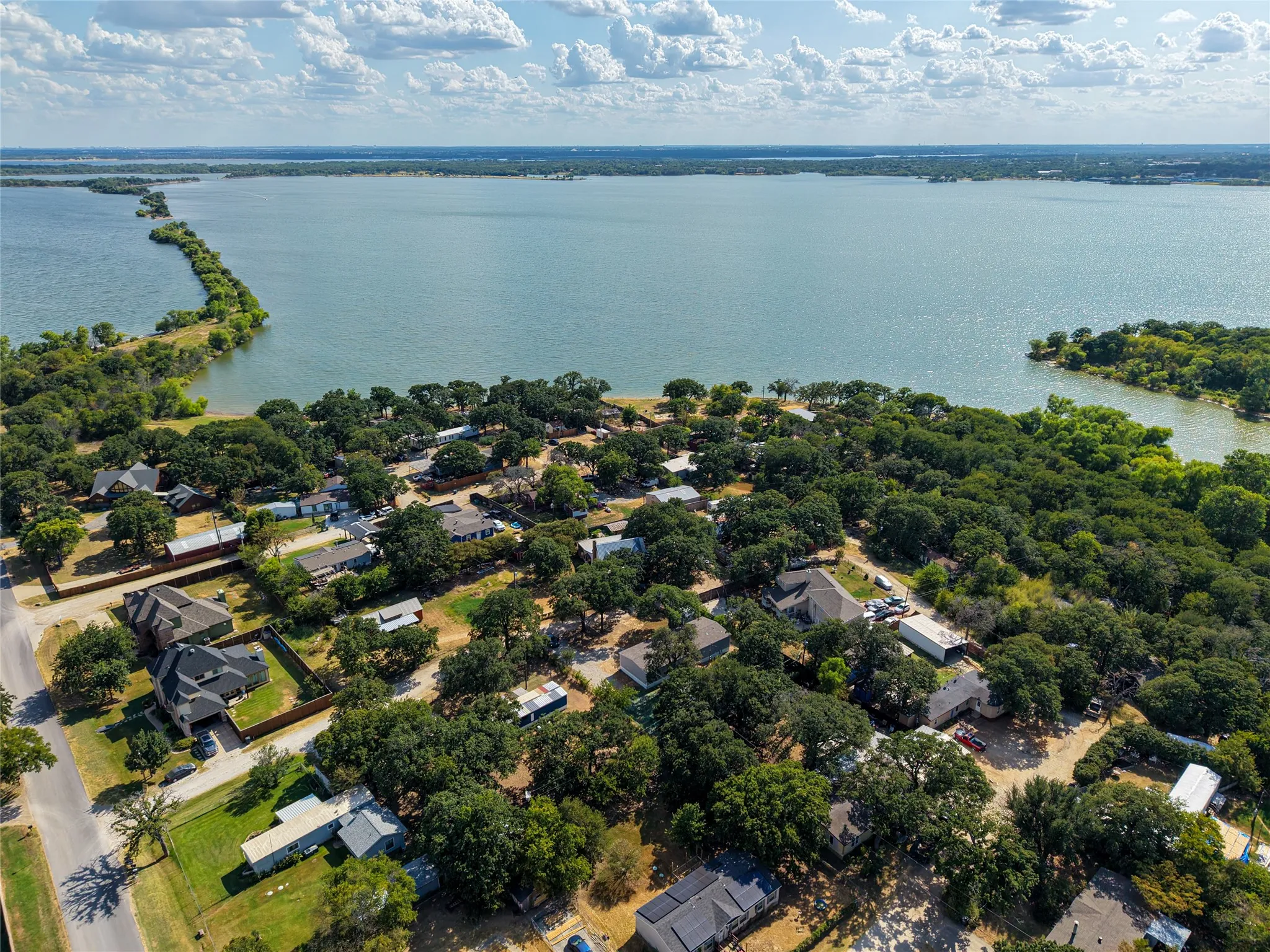 Lakefront setting with surrounding trees, featuring a distinct land bridge extending into the water