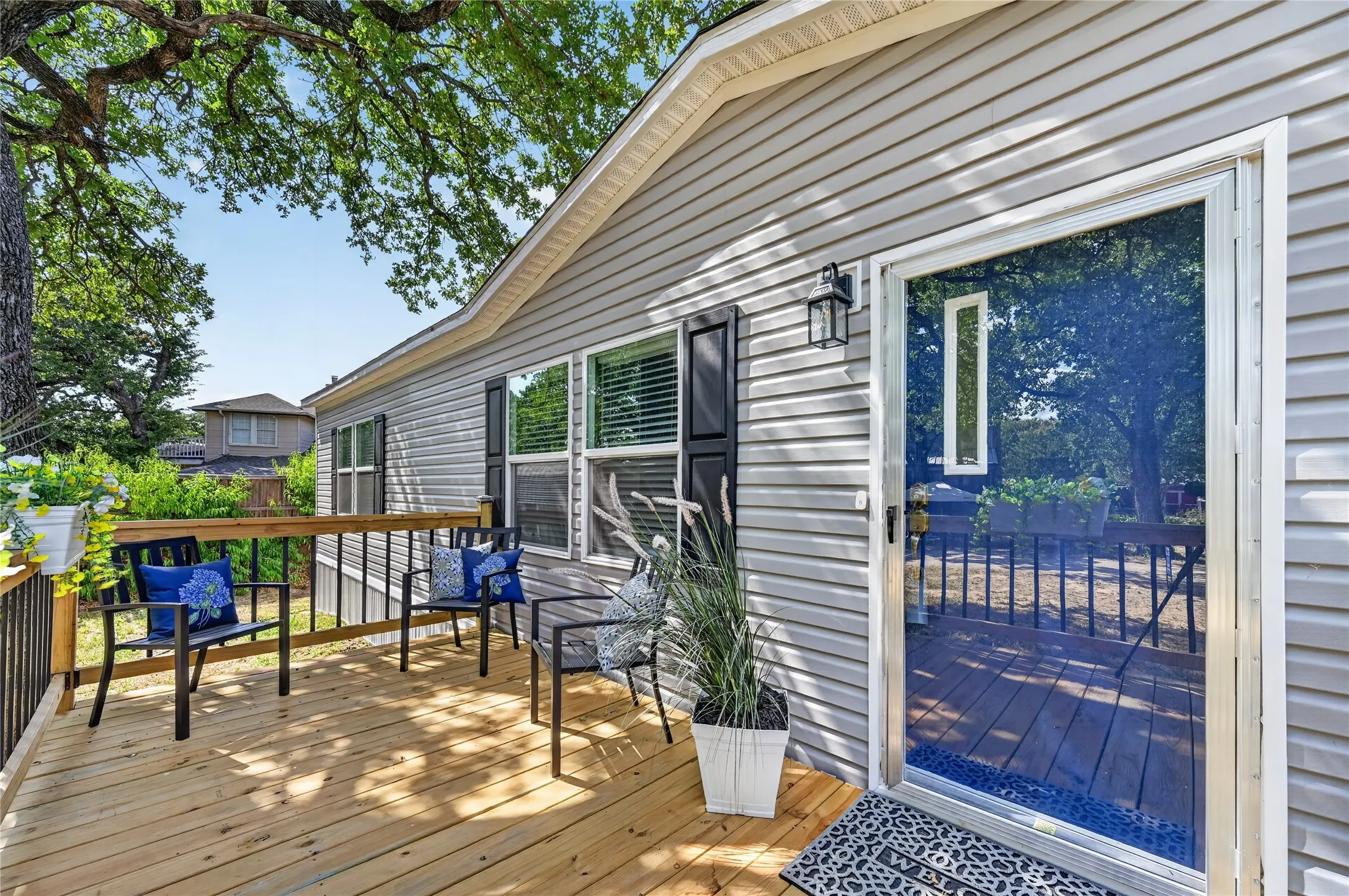 Exterior siding with black window shutters and an overhead light fixture