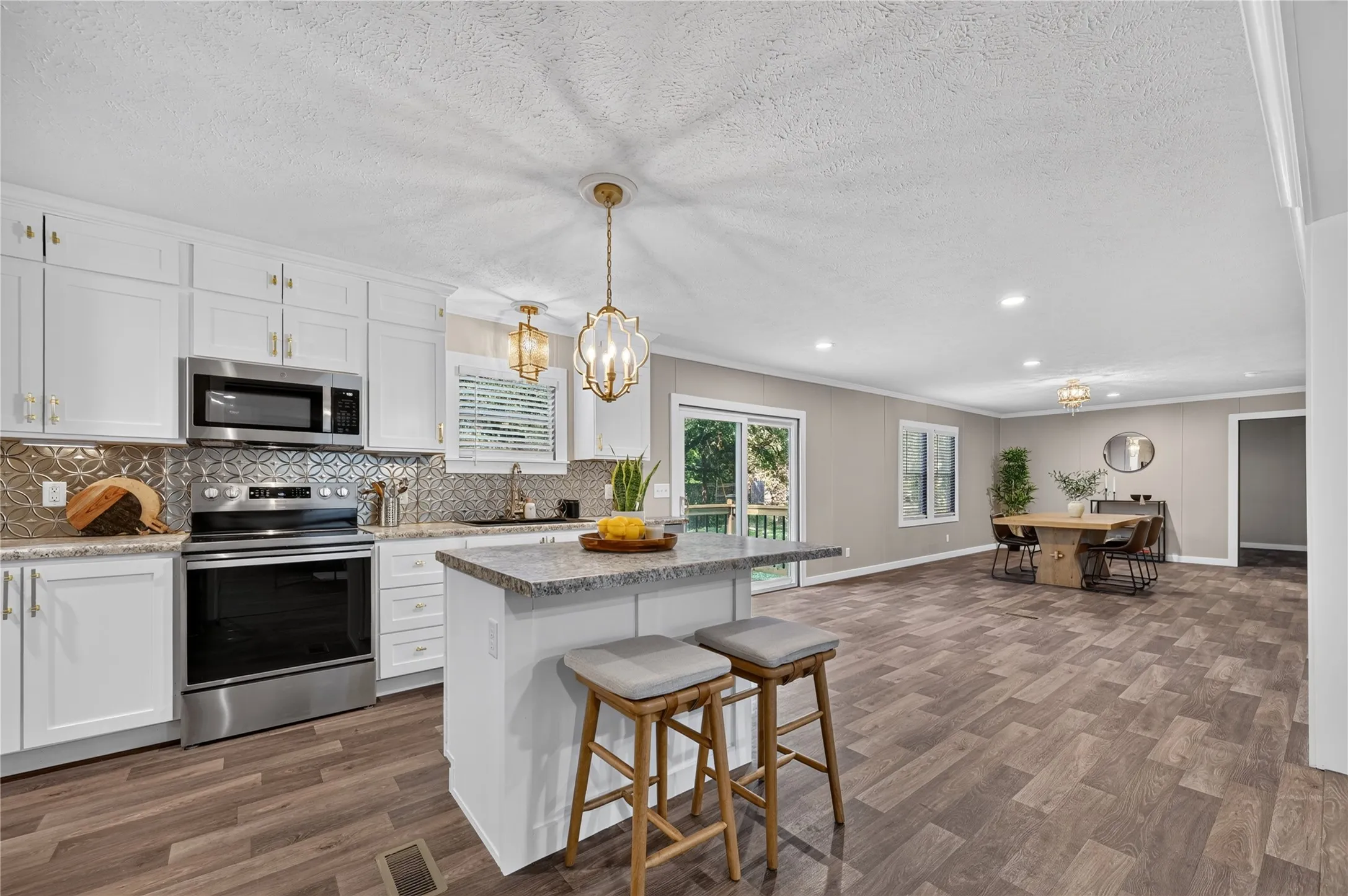 Kitchen with white cabinetry, stainless steel appliances, and a patterned backsplash