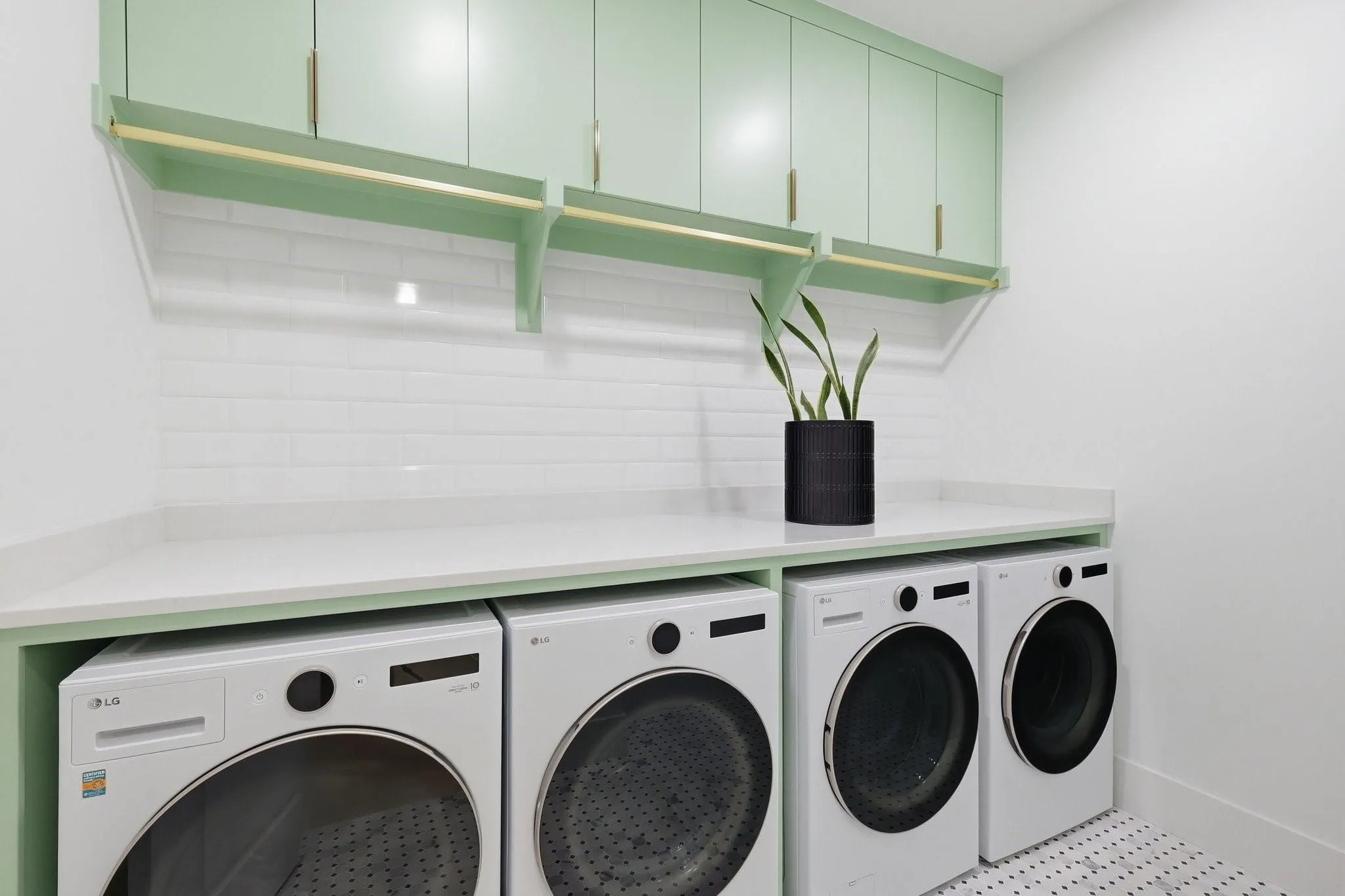 This light-filled Laundry Room offers generous space for dual washers and dryers, framed by custom built-in cabinetry and marble flooring. A thoughtfully designed Mud Hall just outside features custom storage, hooks, and integrated charging outlets.
