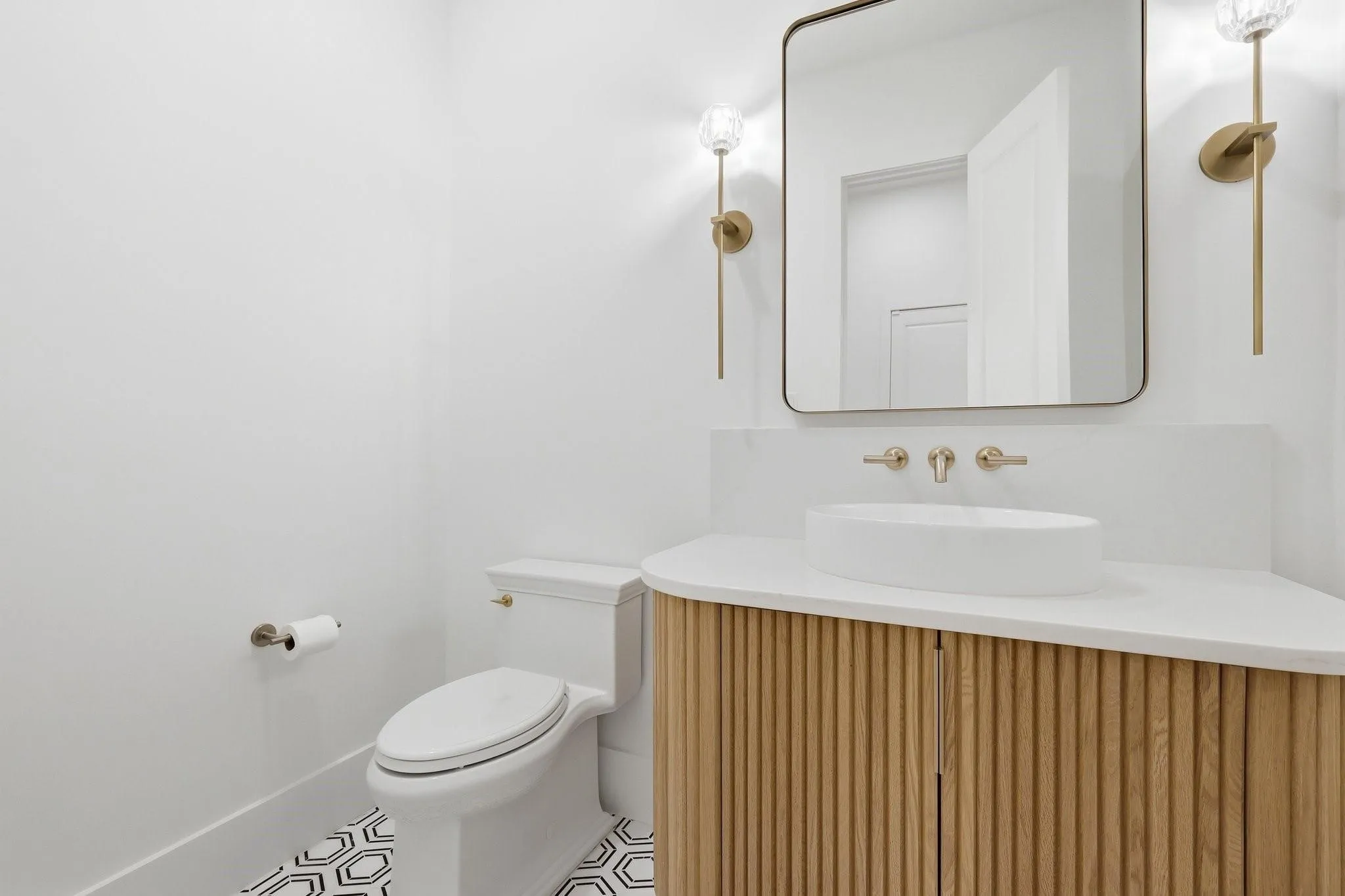 Perfectly placed to serve all Living Areas, this refined Powder Bath features a floating custom vanity with a quartz surface, an artful vessel sink, and marble tile flooring.