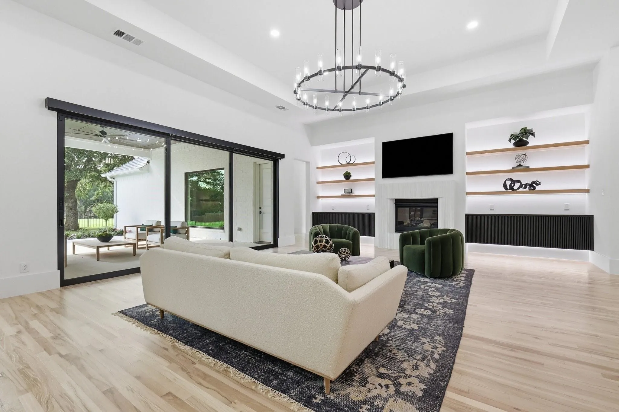 Custom media wall featuring fluted oak cabinetry, floating wood shelves, and integrated LED accent lighting. Includes in-wall inset hardware mounting behind the TV.