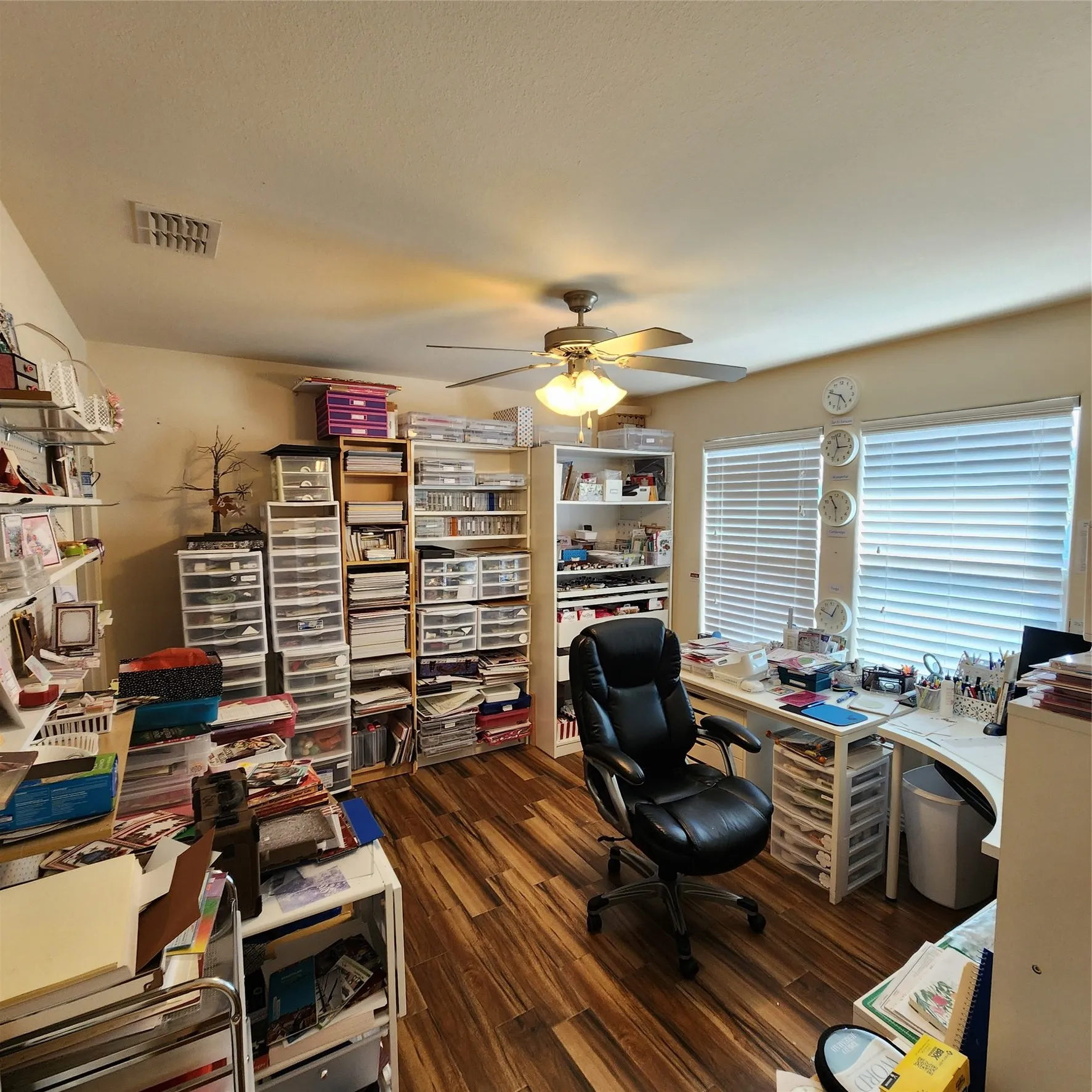 Room featuring wood-finish flooring, a ceiling fan with integrated lighting, and window blinds