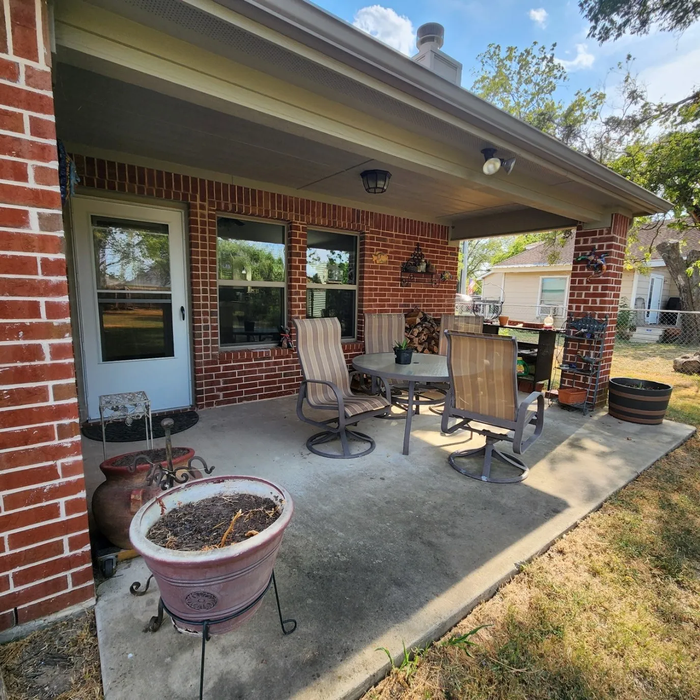 Covered patio with brick column, recessed lighting, and a solid exterior door