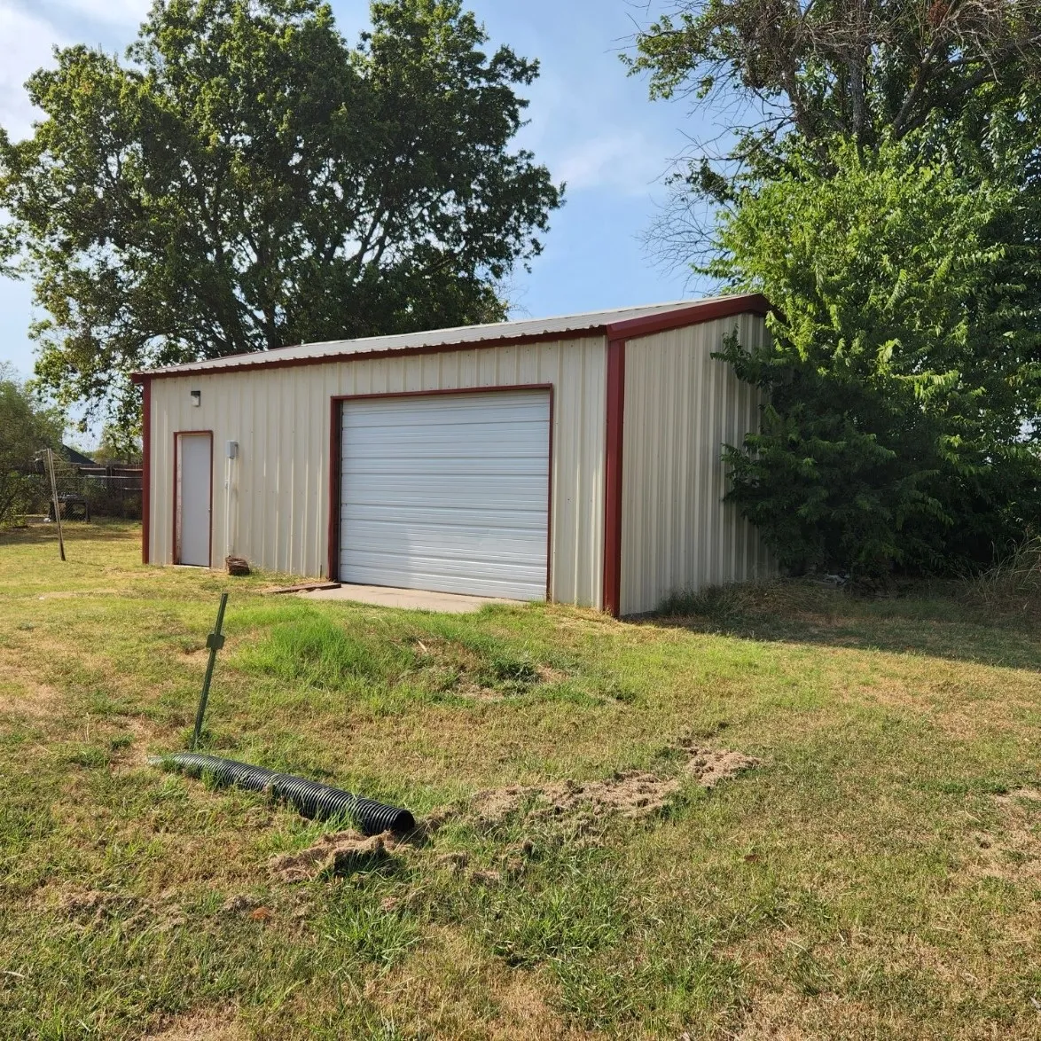 Approx. 20'x30' metal auxiliary building with concrete floor and featuring a roll-up door and a side entry door