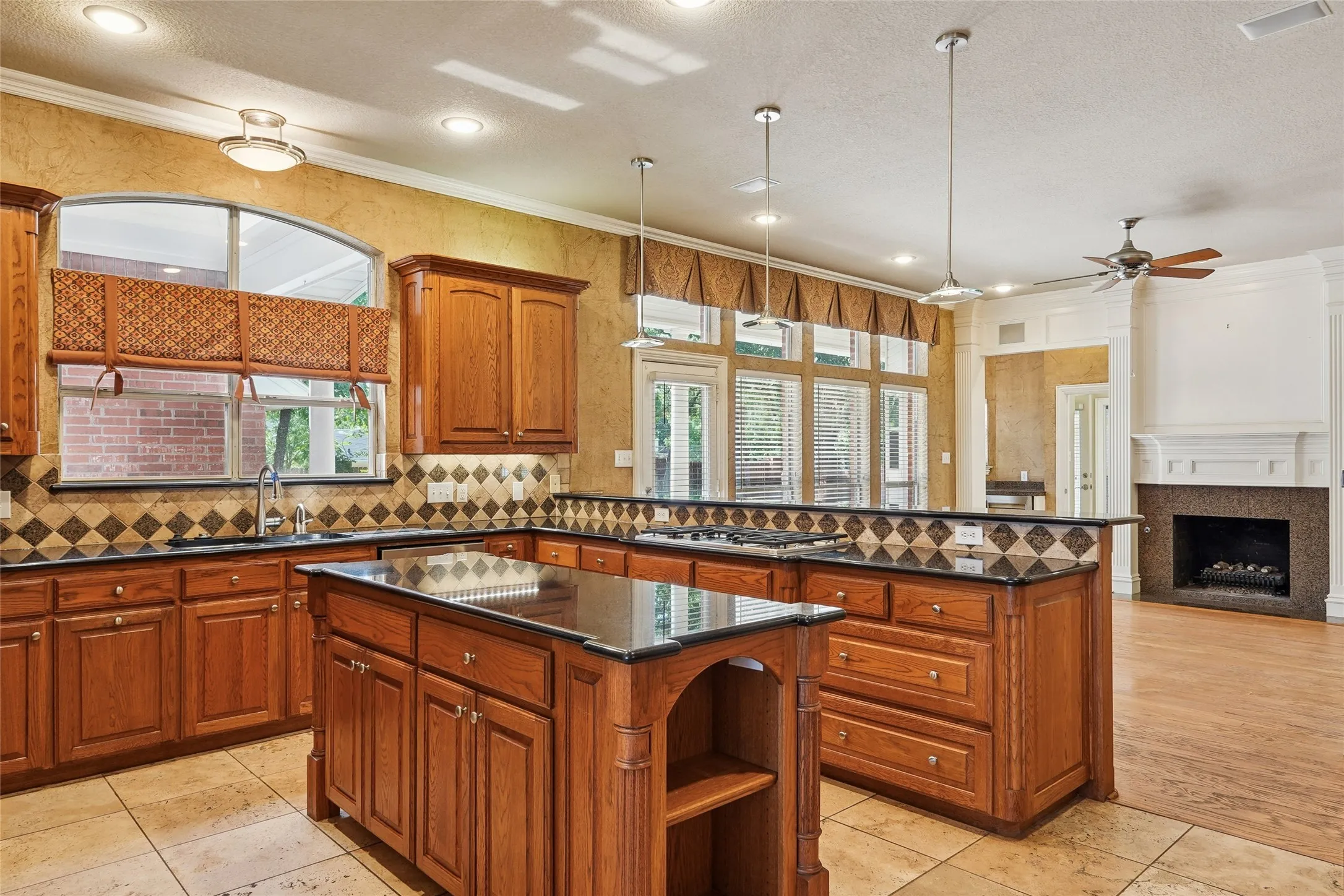 Kitchen featuring wood cabinetry, dark countertops, tiled backsplash, and recessed lighting