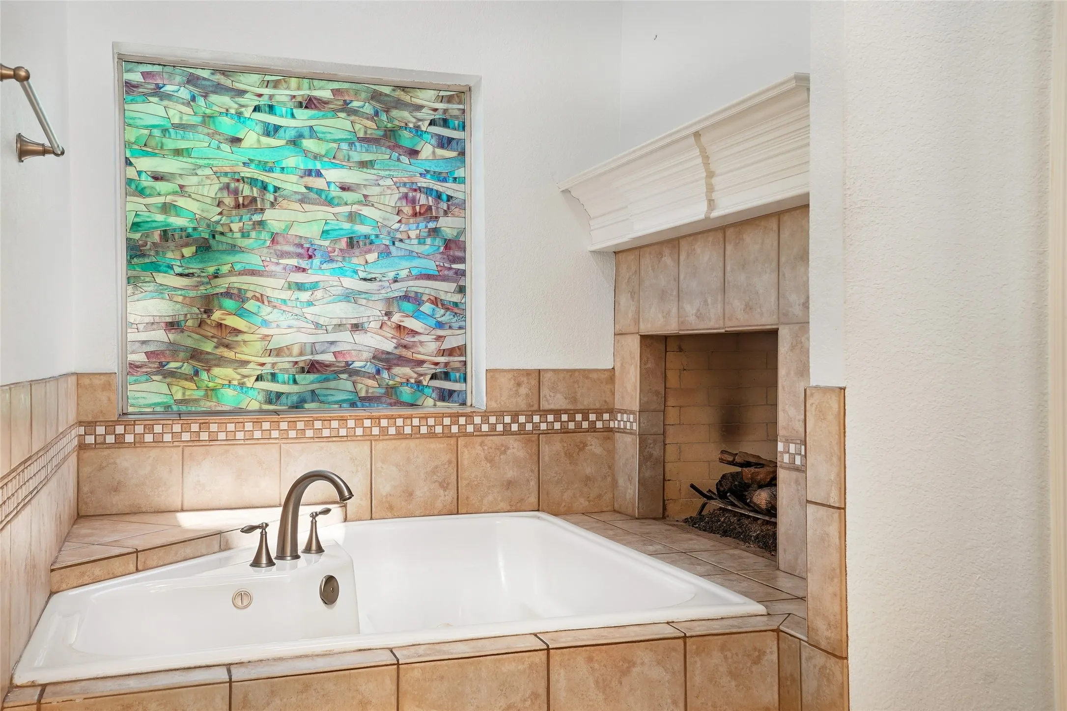 Built-in corner bathtub with a three-piece faucet set, surrounded by ceramic tile