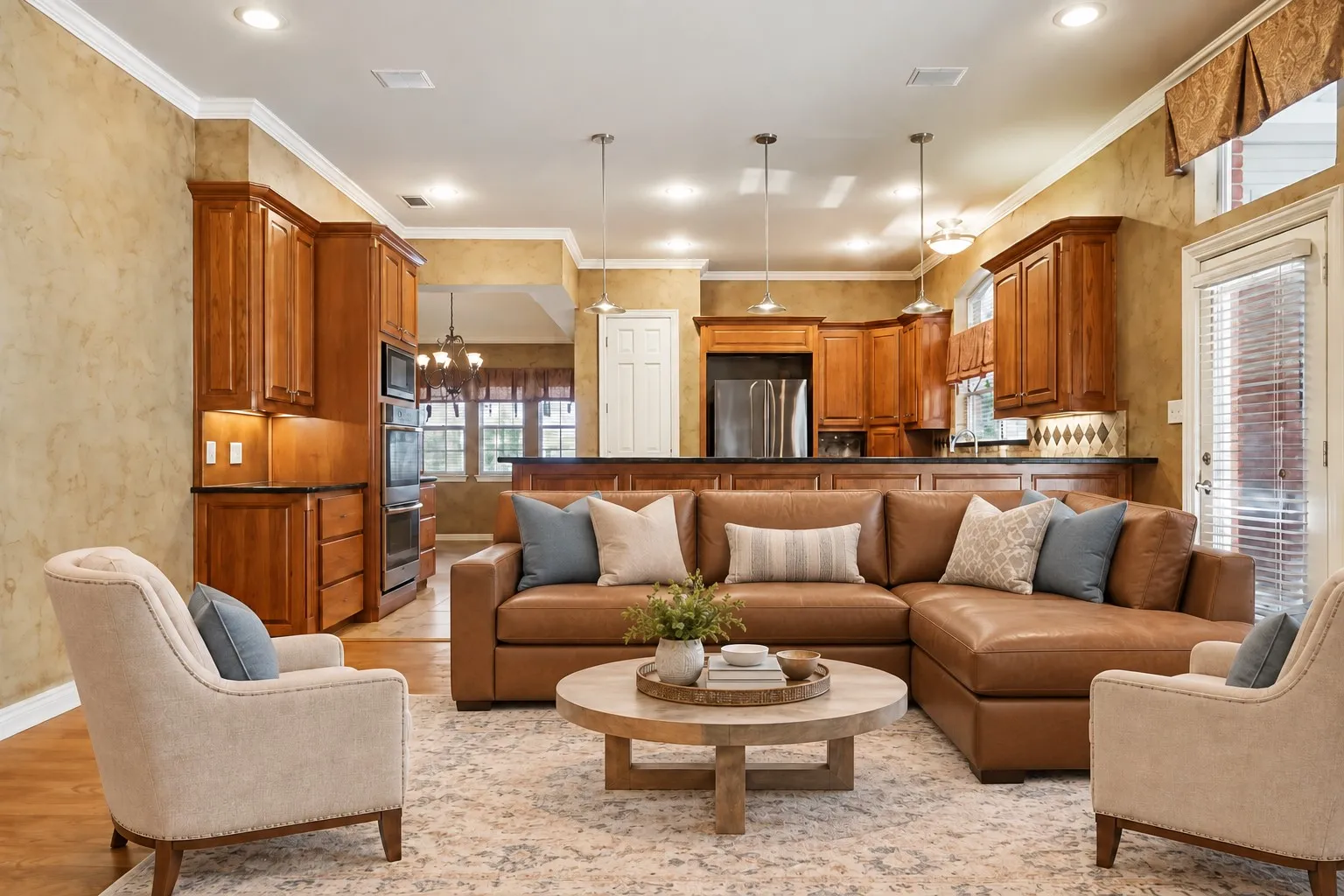 Open-concept living area featuring wood-finish flooring, recessed lighting, crown molding, and a kitchen with wood cabinetry and built-in stainless steel appliances