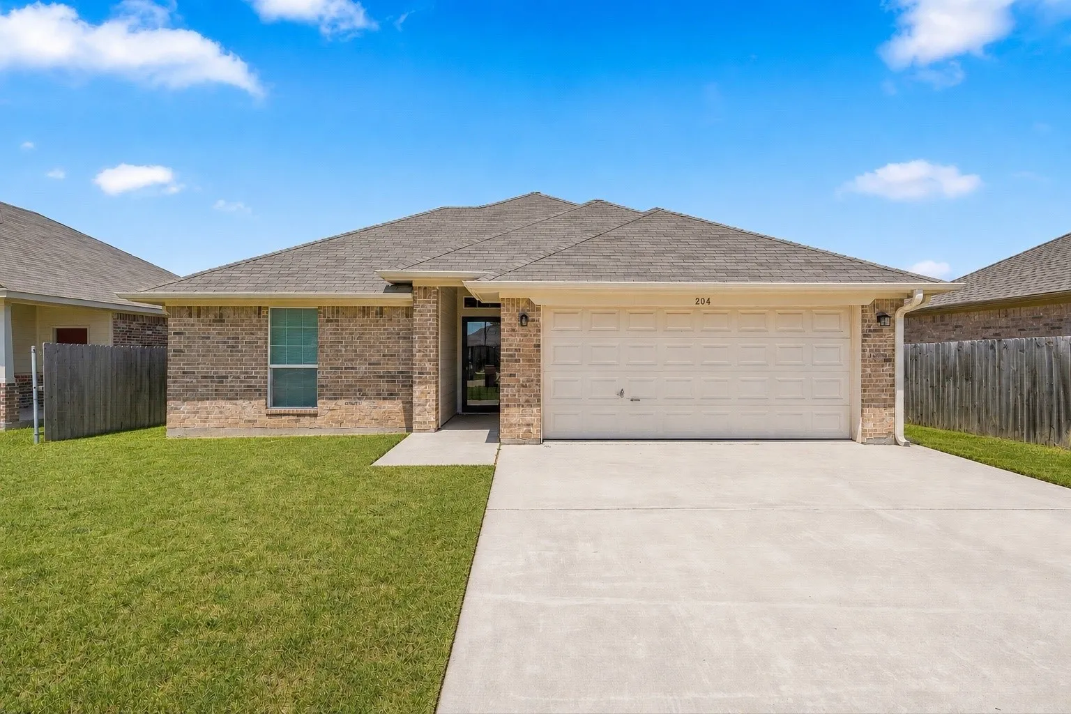 Virtual rendering. Brick exterior with a gabled roof and attached garage