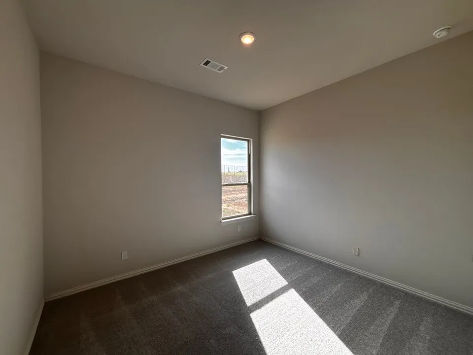 Carpeted room with a single window, recessed lighting, and neutral wall paint