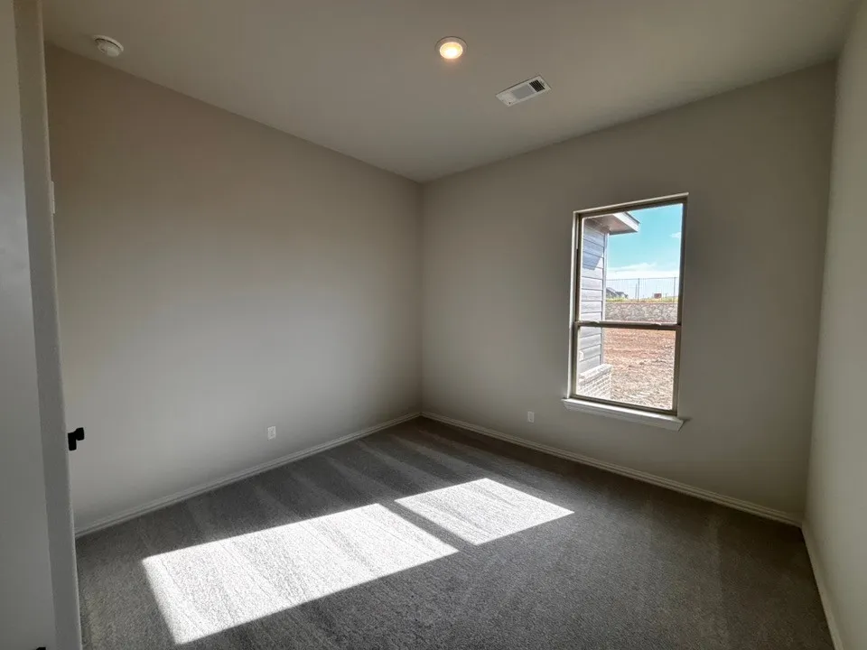 Recessed ceiling lighting, textured carpet flooring, window with white trim, and neutral wall tones