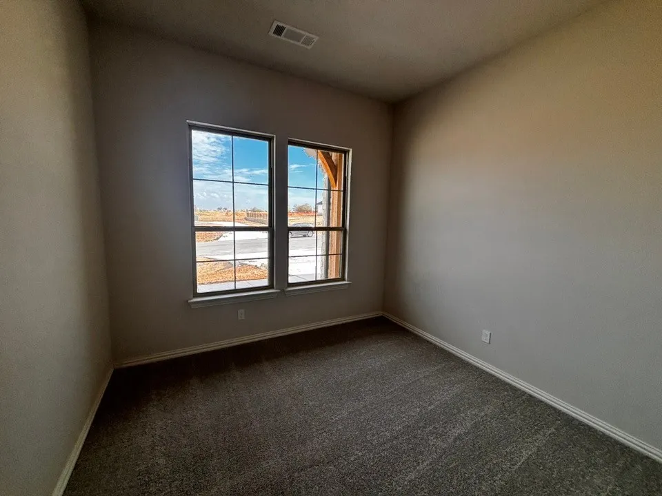 Dual pane windows with grid pattern, neutral wall paint, white trim, and gray carpet